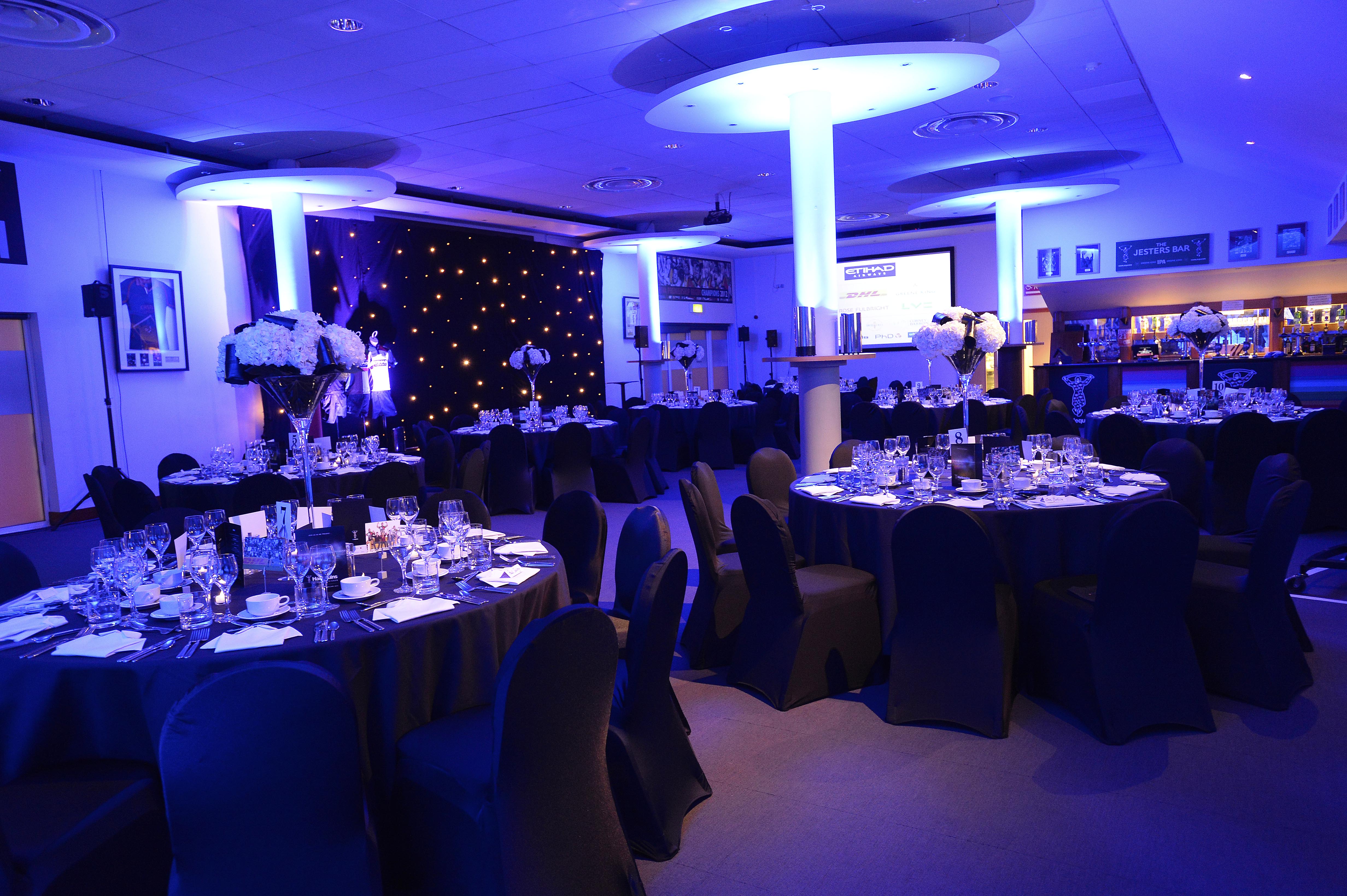 Elegant gala setup with round tables and white flower centerpieces at Twickenham Stoop.