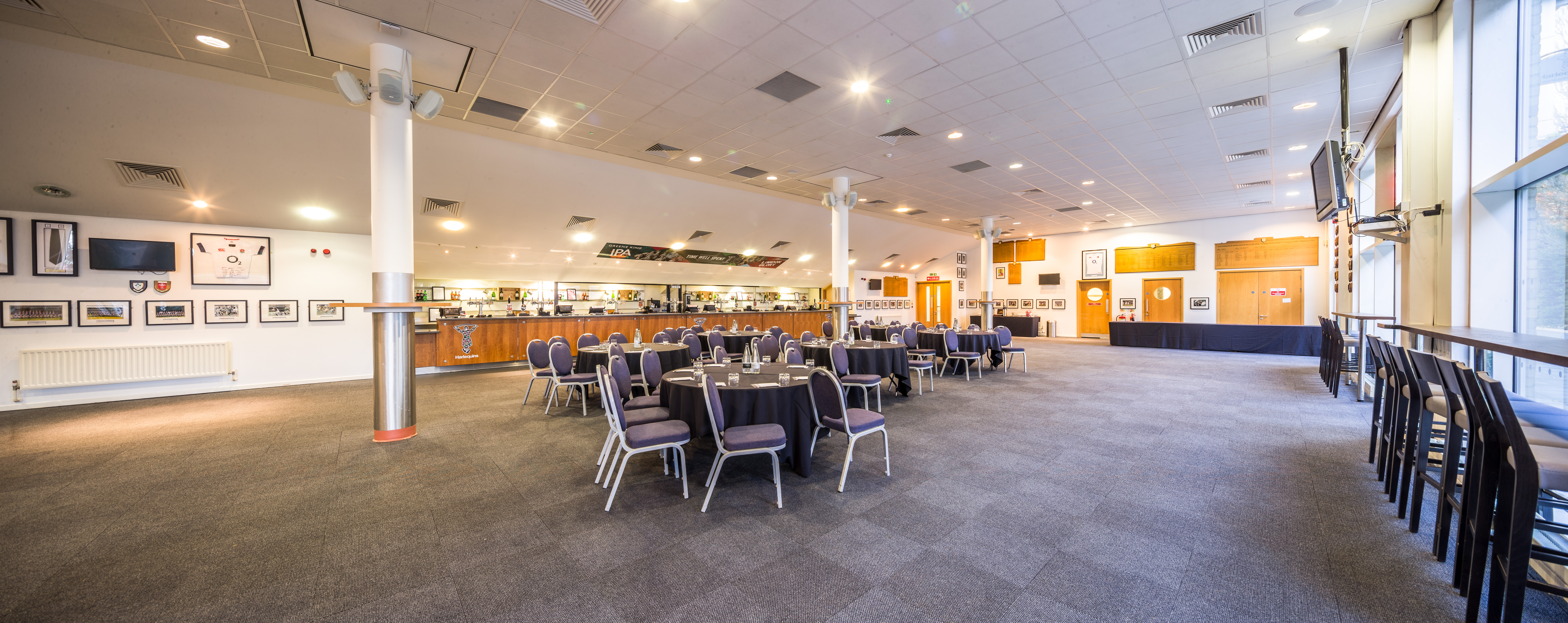 Spacious Honours Bar at Twickenham Stoop, set for formal events with round tables.
