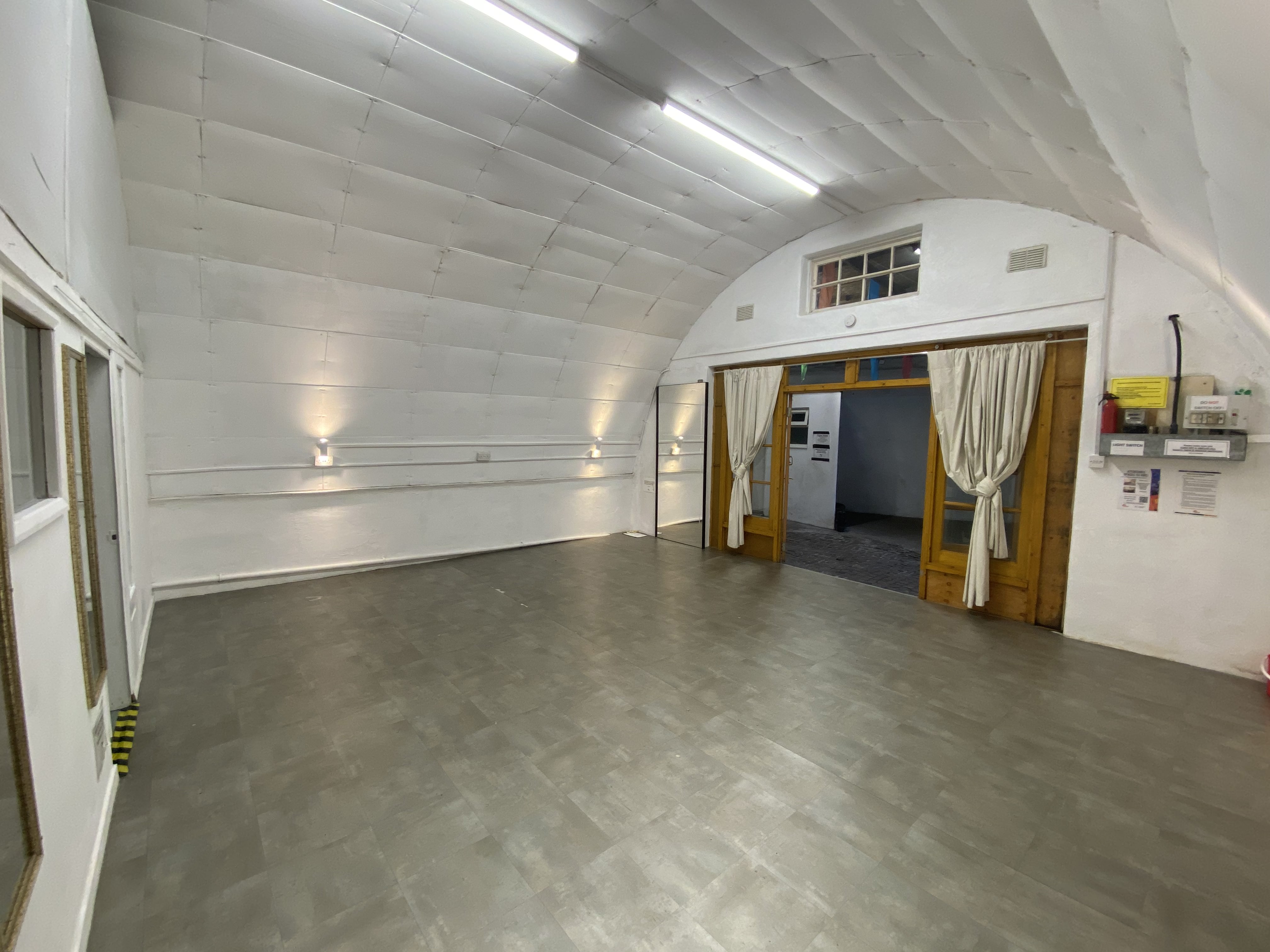 Versatile event space with arched ceiling, ideal for meetings and workshops.