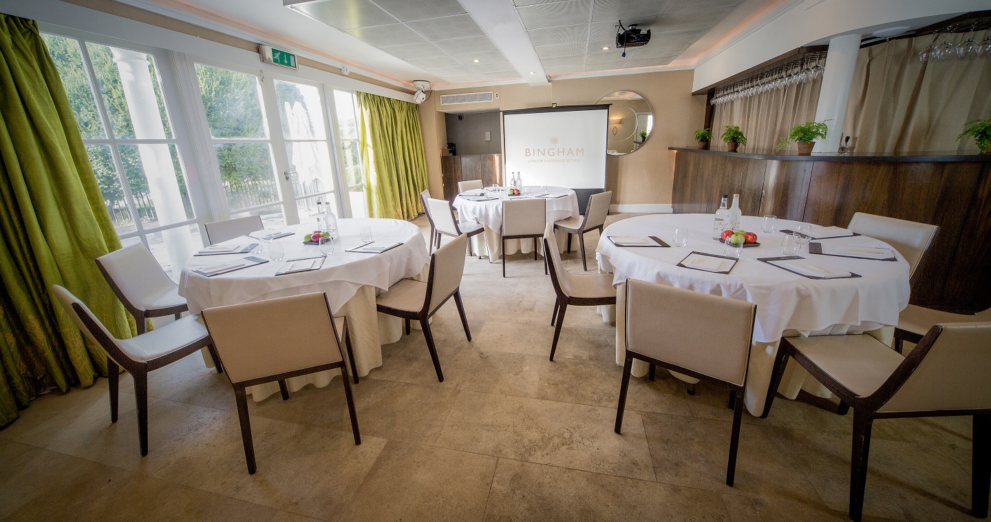 Elegant meeting space with round tables, ideal for workshops and small conferences.