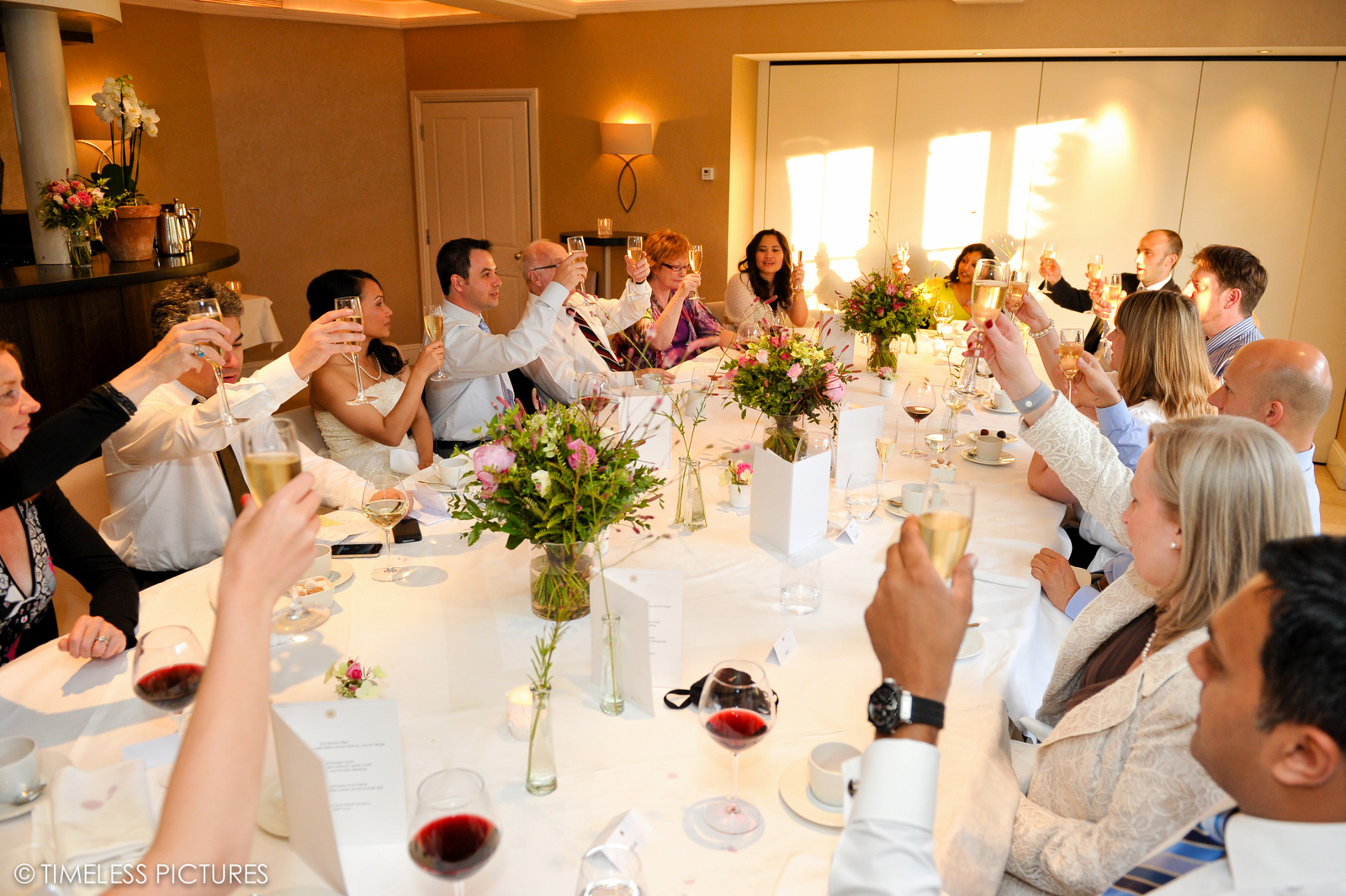 Celebratory gathering in Garden Room 3 with elegant table settings and floral centerpieces.