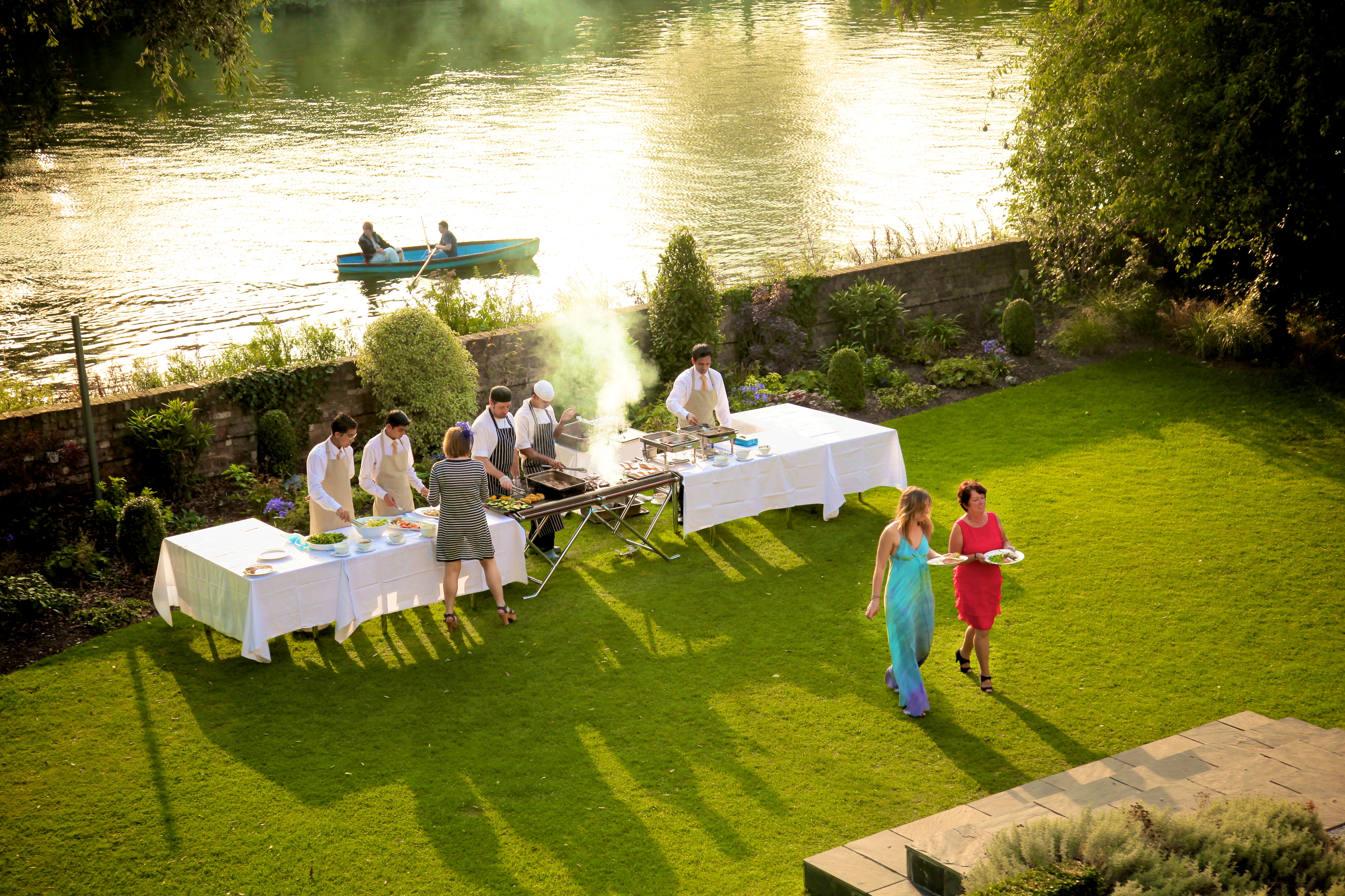 Outdoor event setup with barbecue by riverside at The Bingham, perfect for summer gatherings.