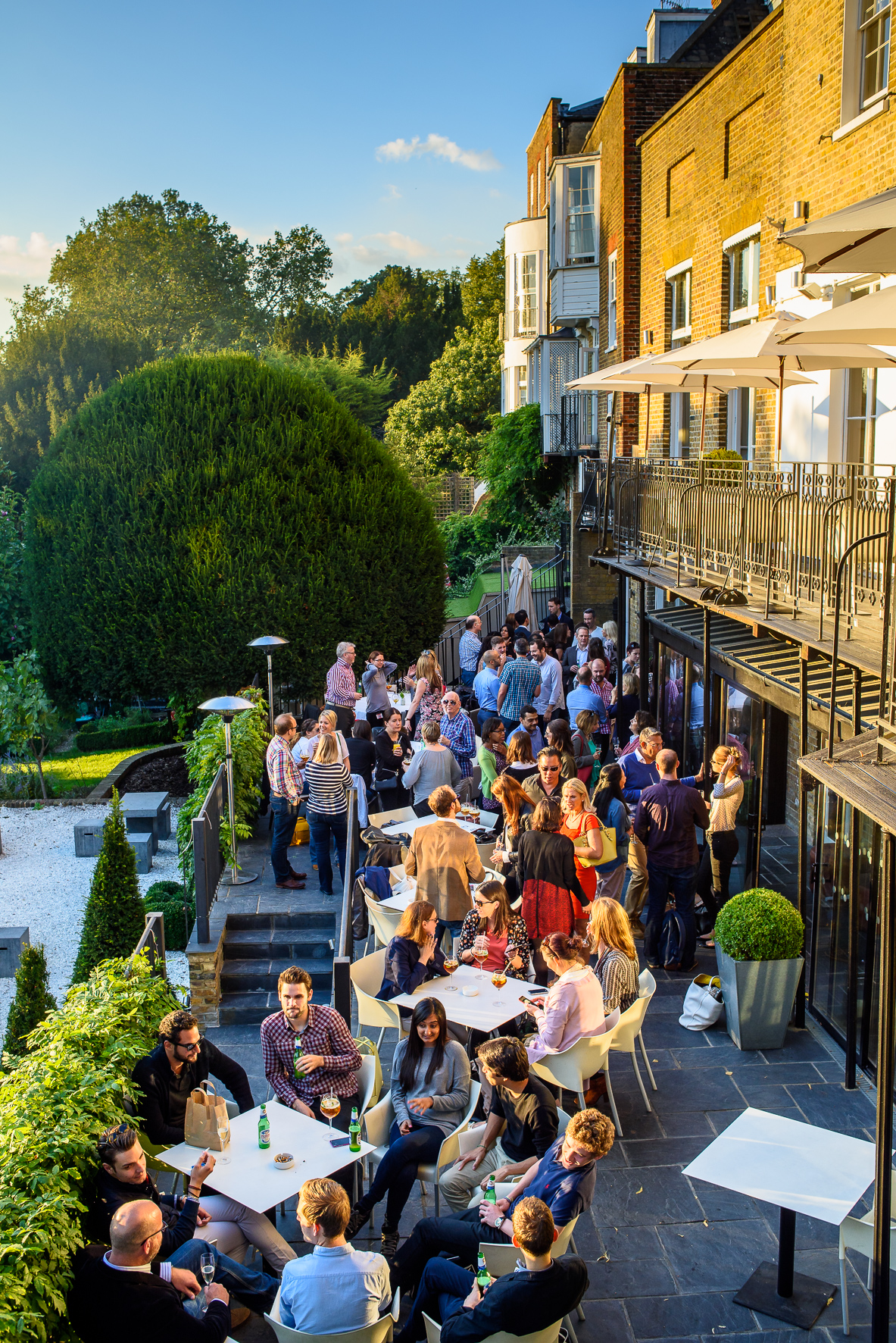 Vibrant outdoor networking event at The Bingham's Terrace & Garden with lush greenery.
