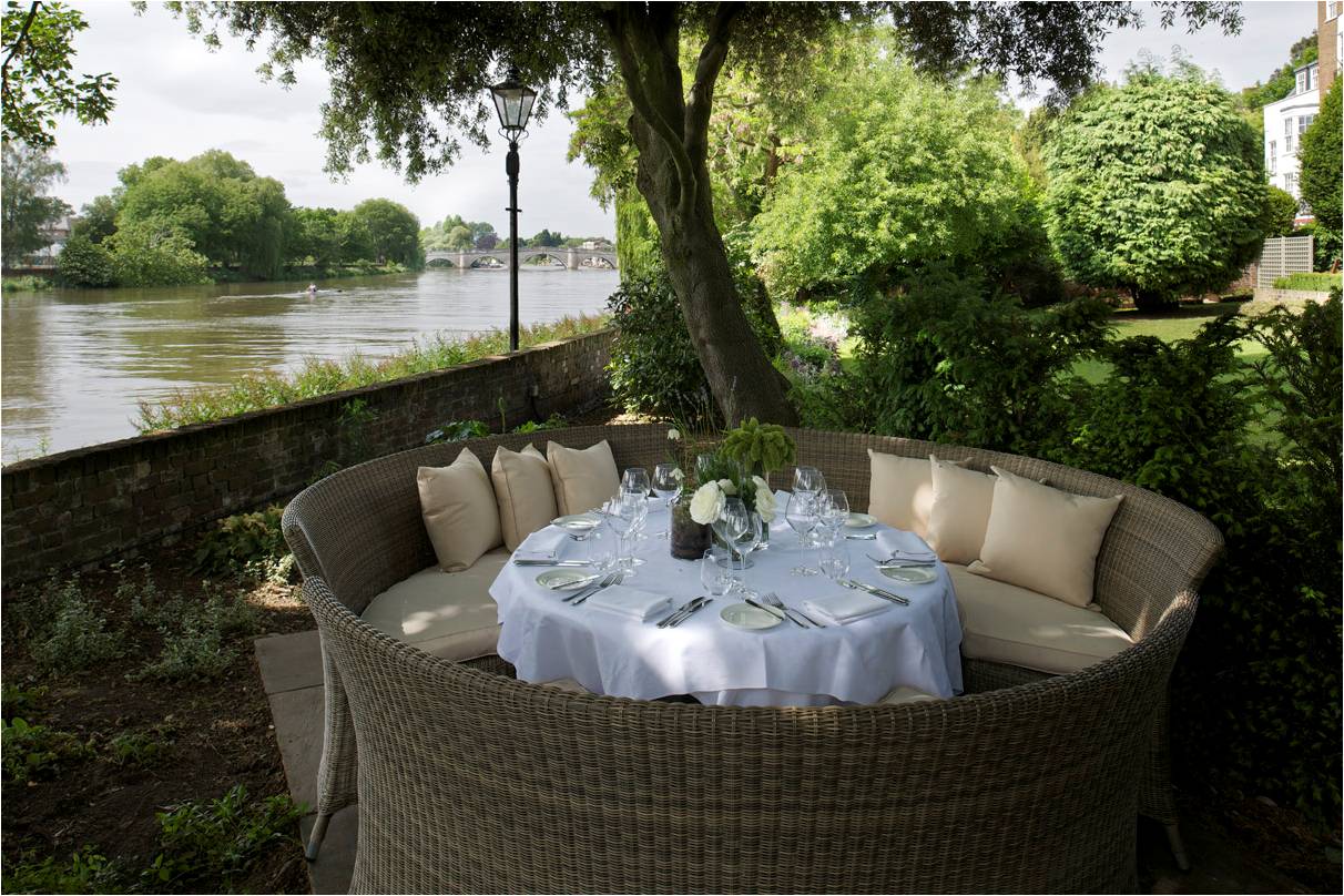 Elegant outdoor dining area by river at The Bingham, perfect for upscale events and gatherings.