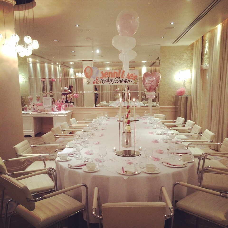 Elegant banquet table with pink and white decor for a baby shower celebration.