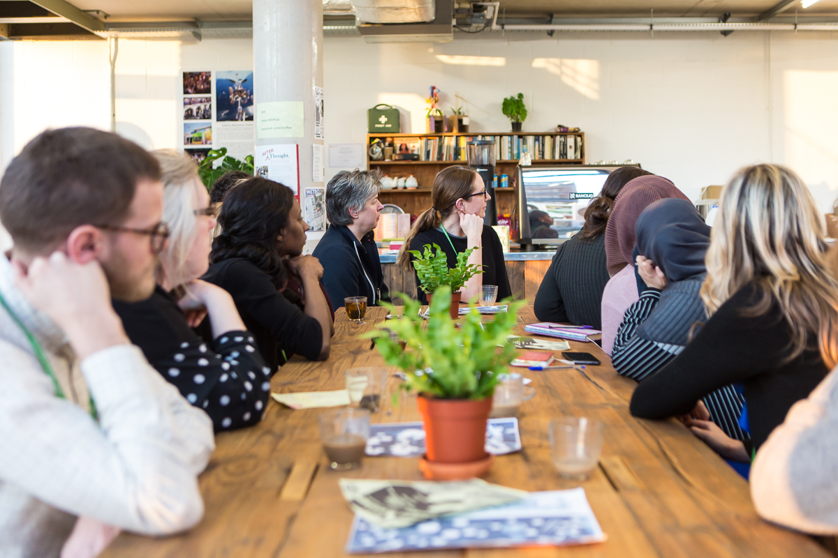 Diverse professionals in a collaborative meeting at R.A.W Labs' Mezanine Floor.