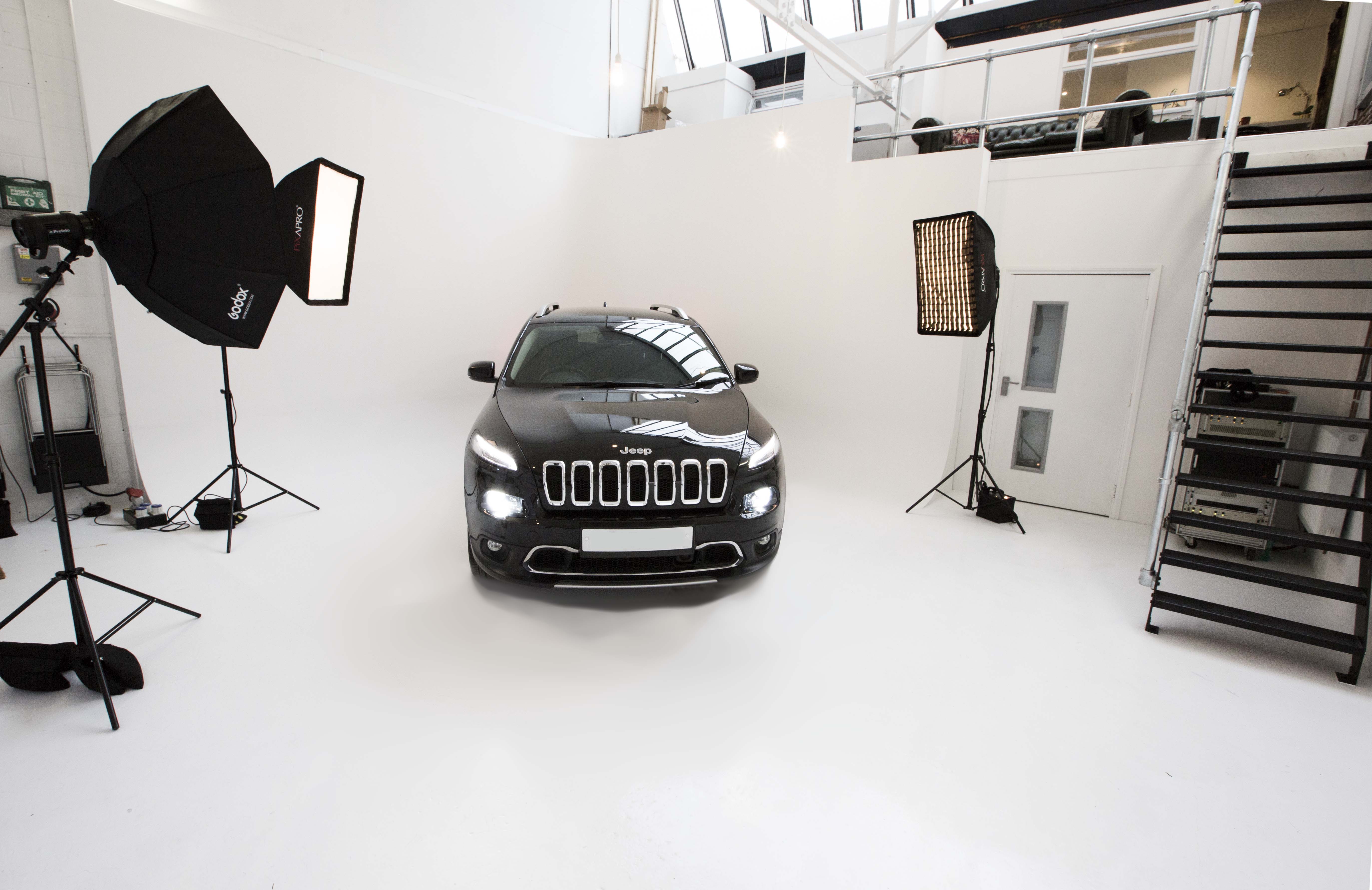 Sleek vehicle in minimalist studio for automotive product launch event.