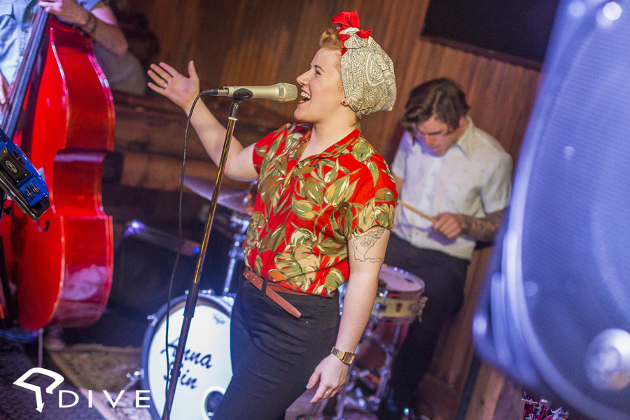 Vibrant live performance at Dive NQ with dynamic singer and retro attire.