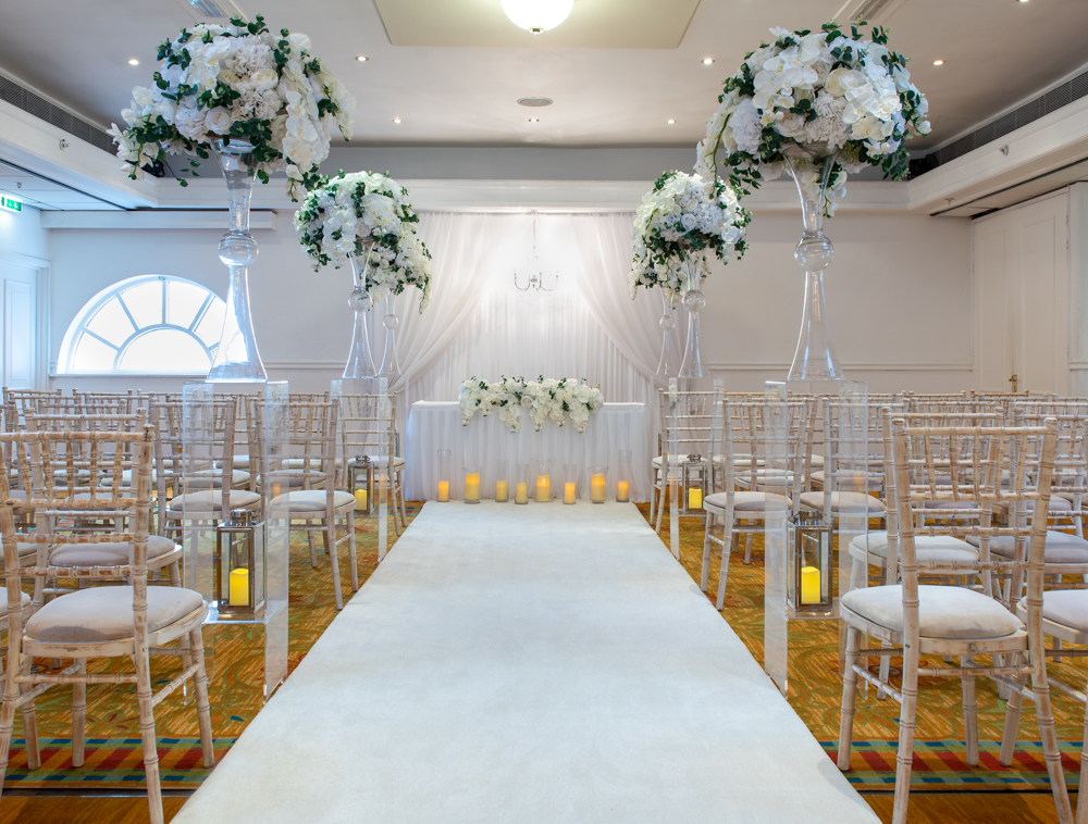Elegant wedding ceremony setup in Thurnham Suite with floral arrangements and candles.