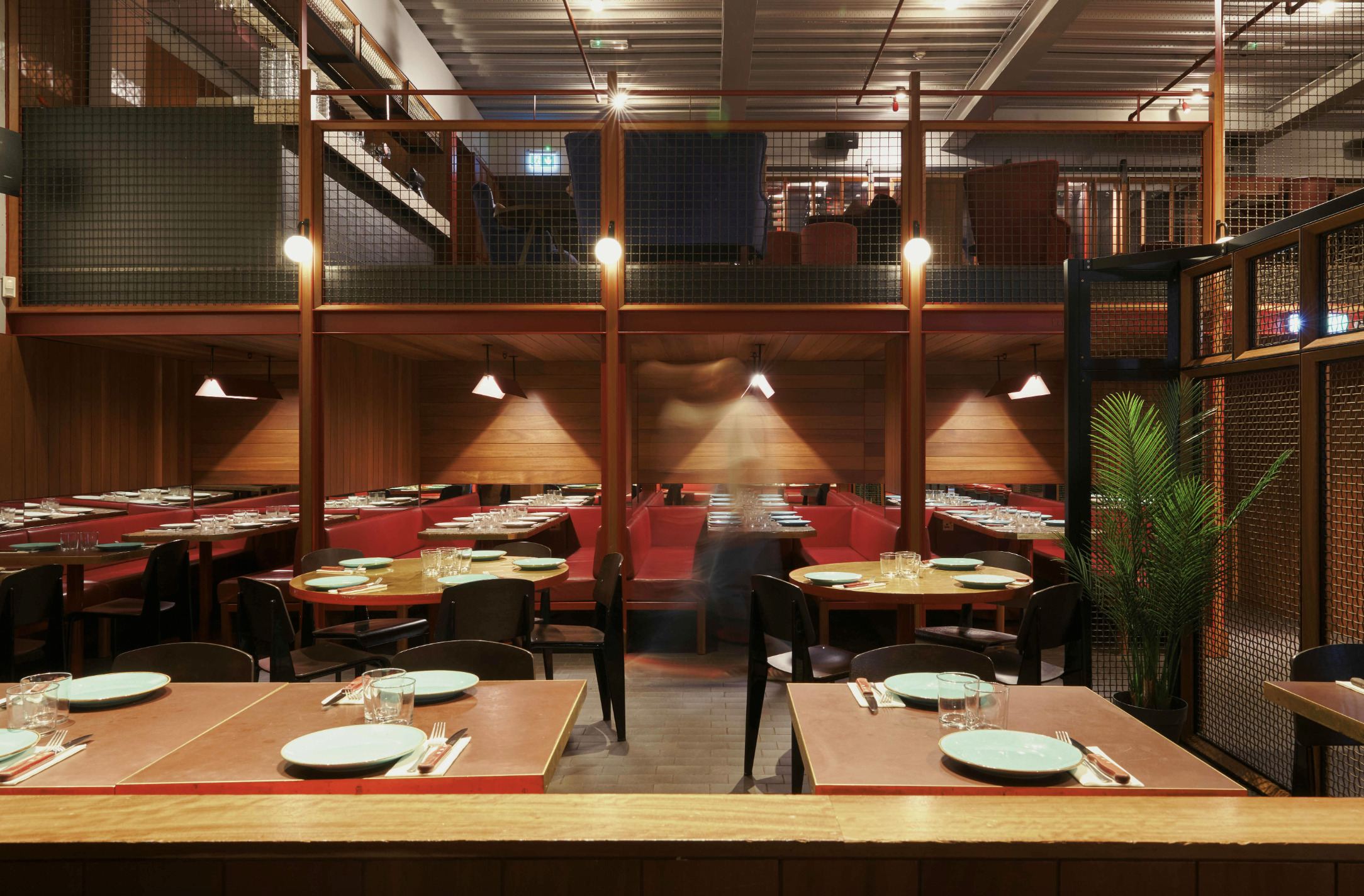 Temper City event space: red banquettes, round tables, industrial chic.