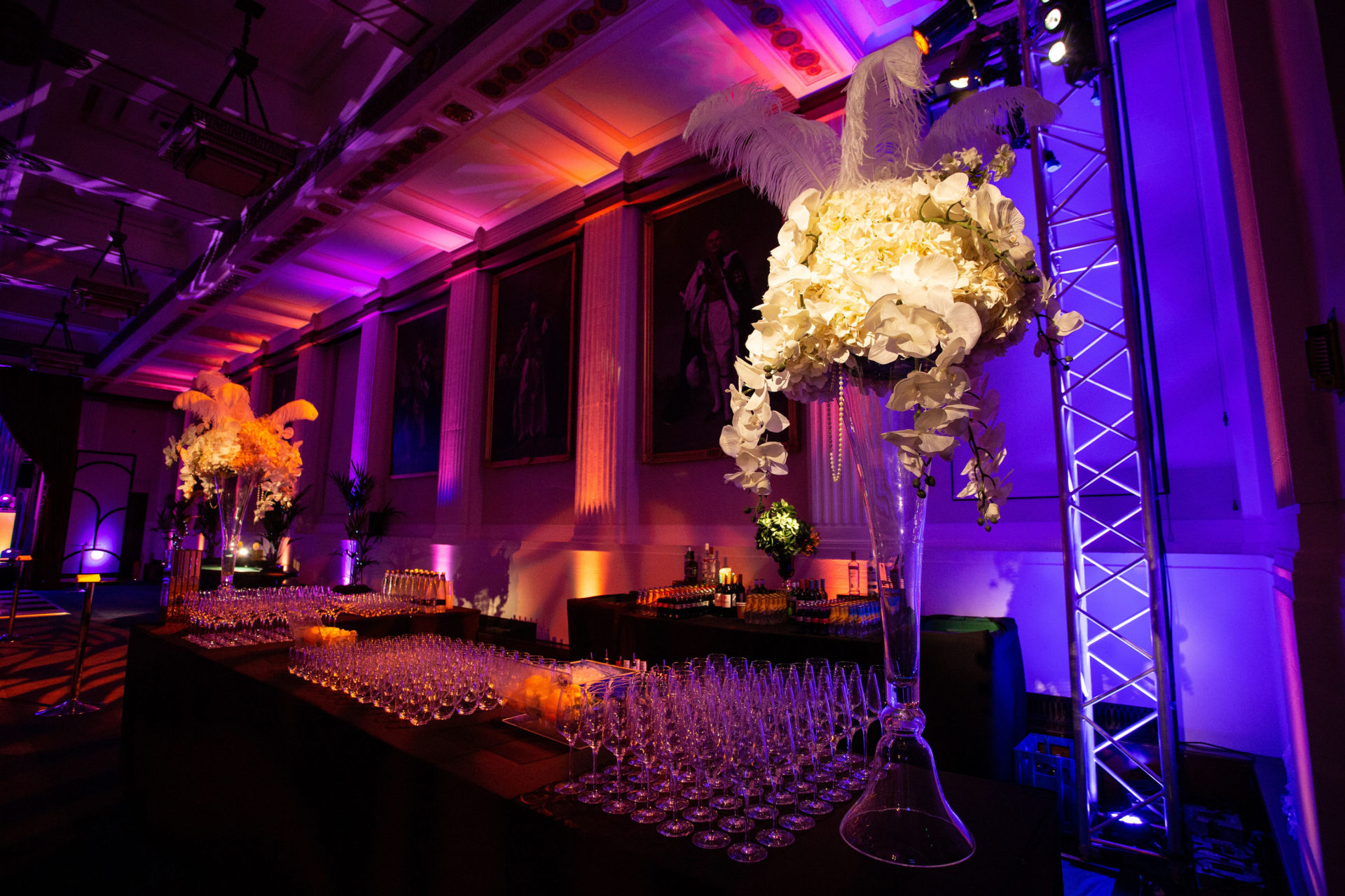 Elegant Christmas party setup with floral arrangements and purple lighting at Freemasons' Hall.