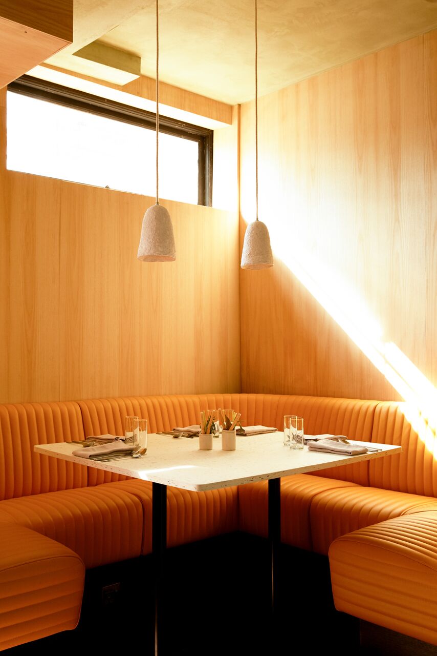 Modern restaurant meeting space with cozy booth, ideal for gatherings and brainstorming.