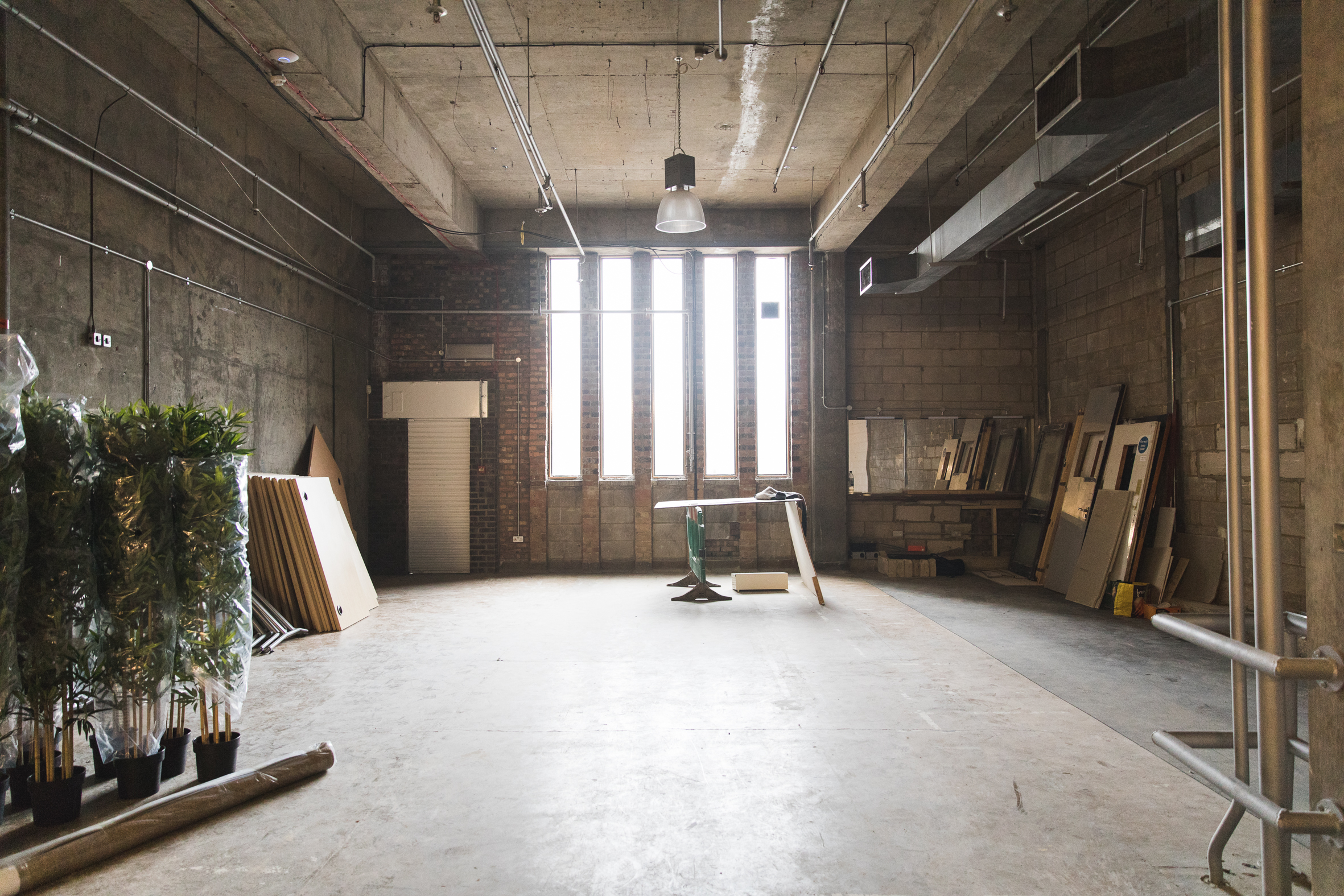 Atrium in Many Hands: raw event space with exposed concrete walls for customizable gatherings.