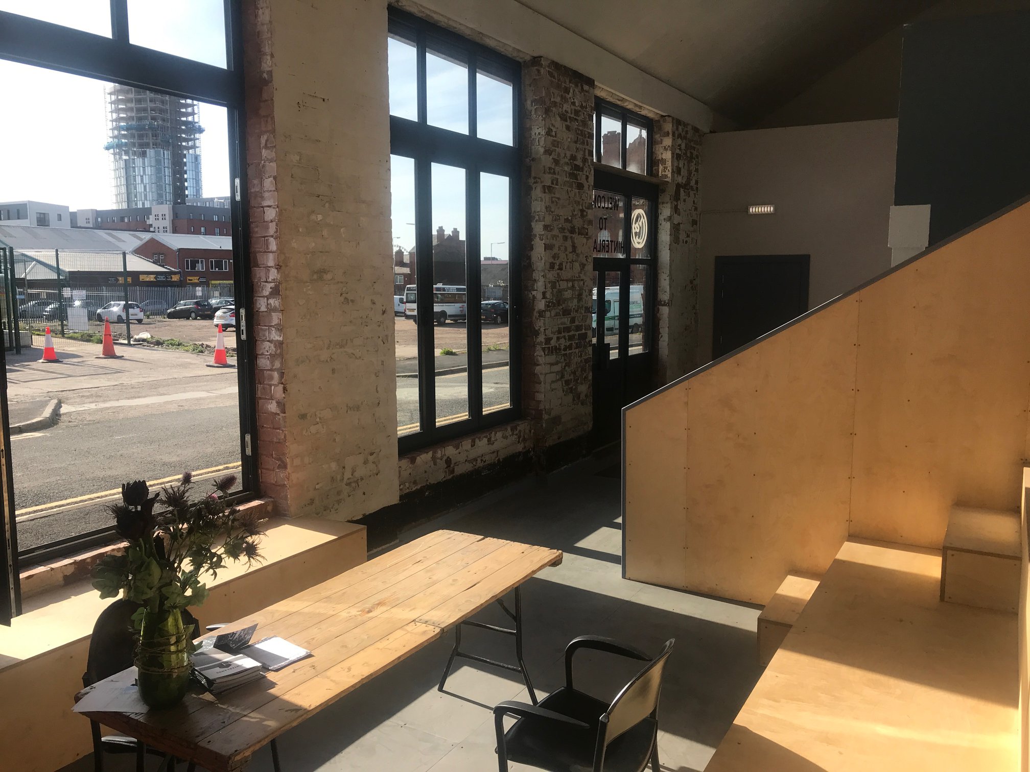 Modern industrial meeting space with large windows, perfect for workshops and gatherings.