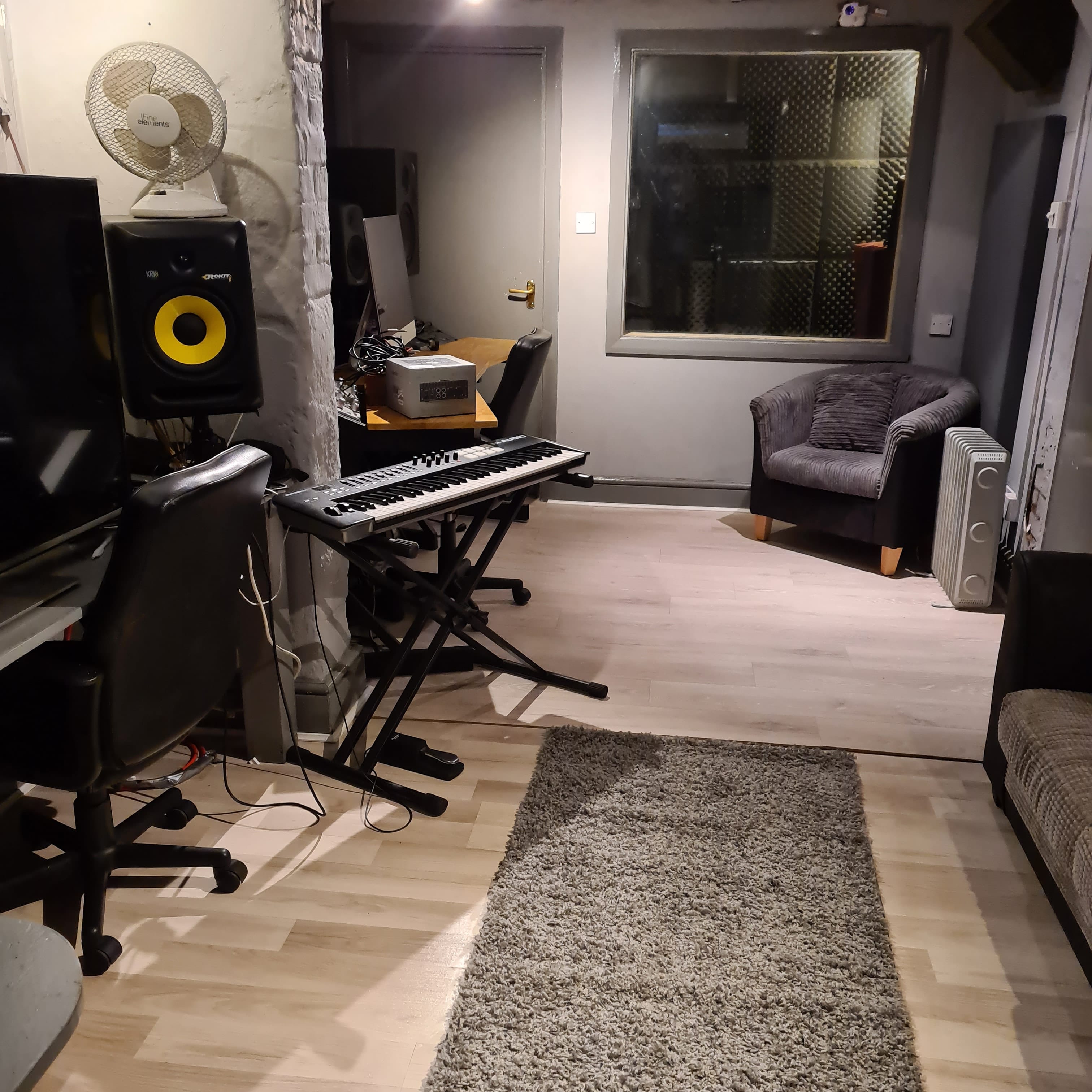 Cozy recording studio with keyboard, ideal for music workshops and brainstorming sessions.