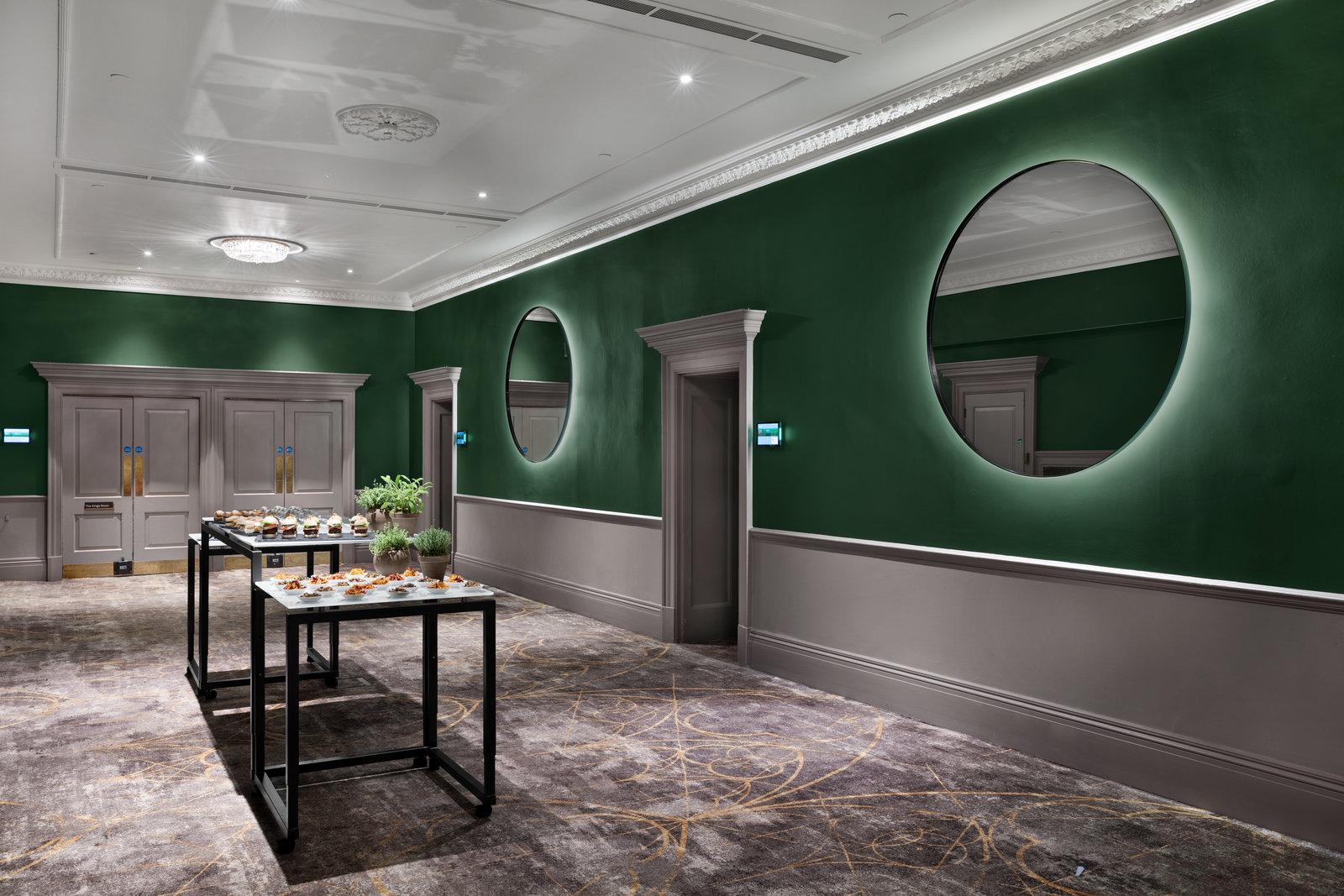 Green walls and backlit mirrors in Bristol Marriott Royal Hotel for networking or coffee breaks.