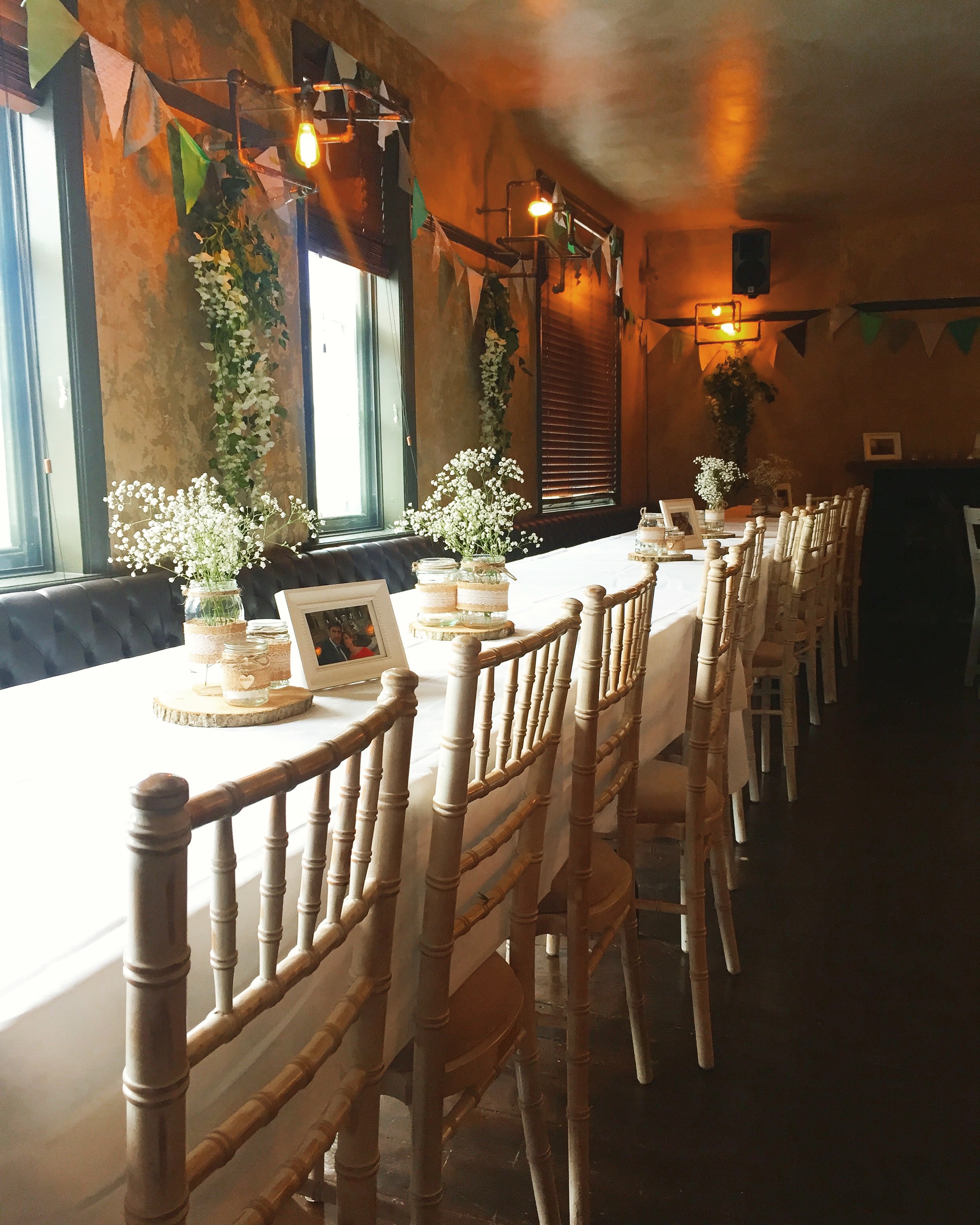 Elegant music room event setup with floral centerpieces and warm lighting.