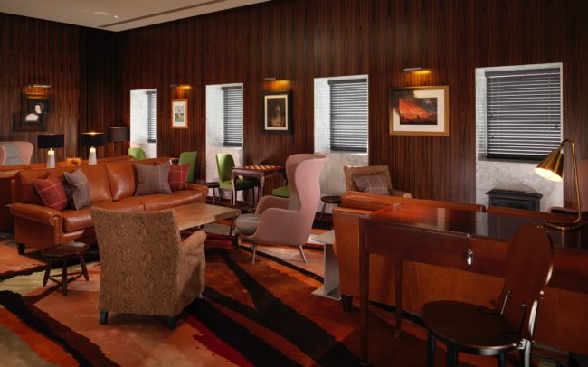 Sophisticated lounge with warm wood paneling for networking events and meetings.