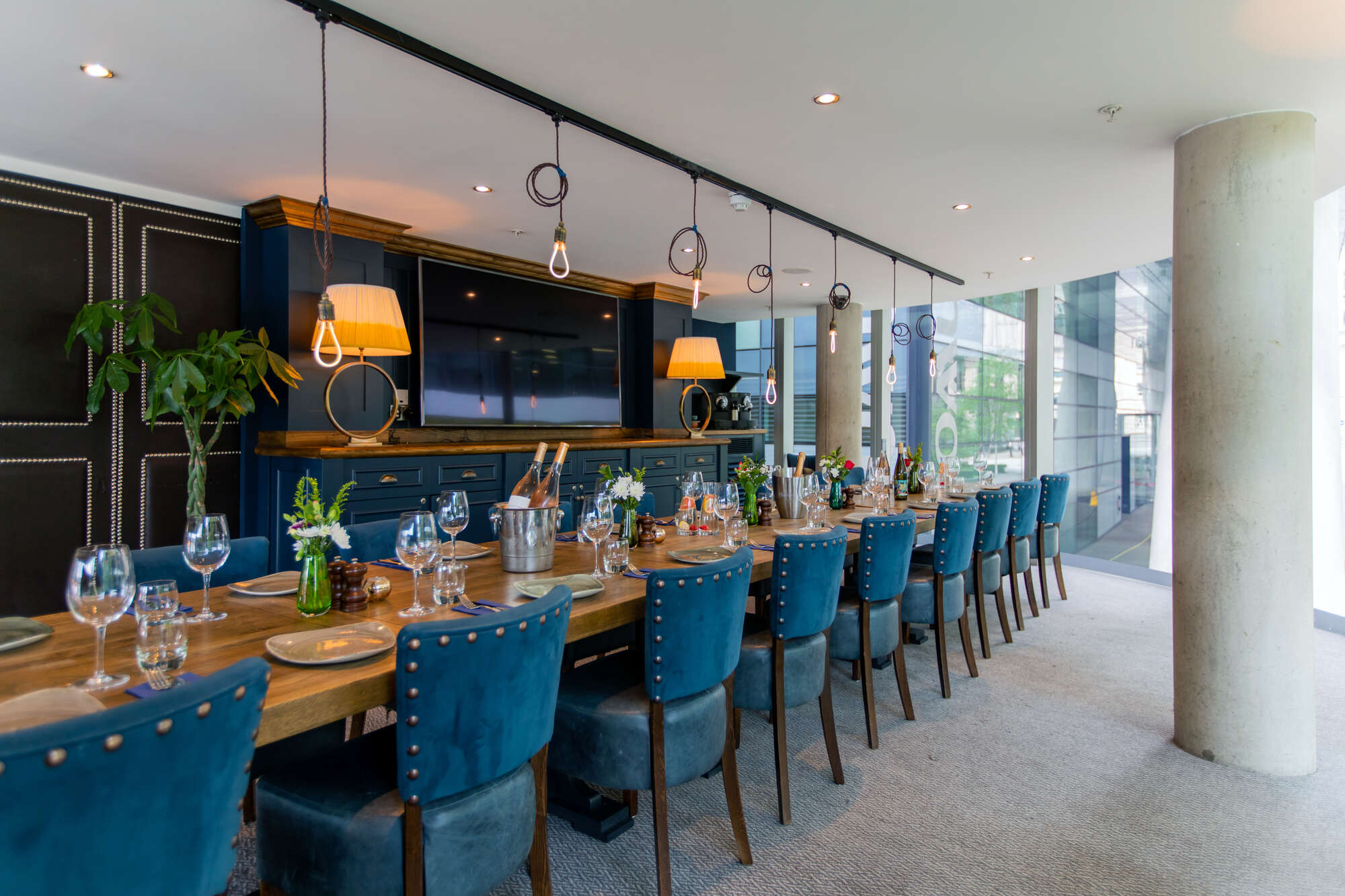 Sophisticated meeting space with wooden table and blue chairs for corporate events.