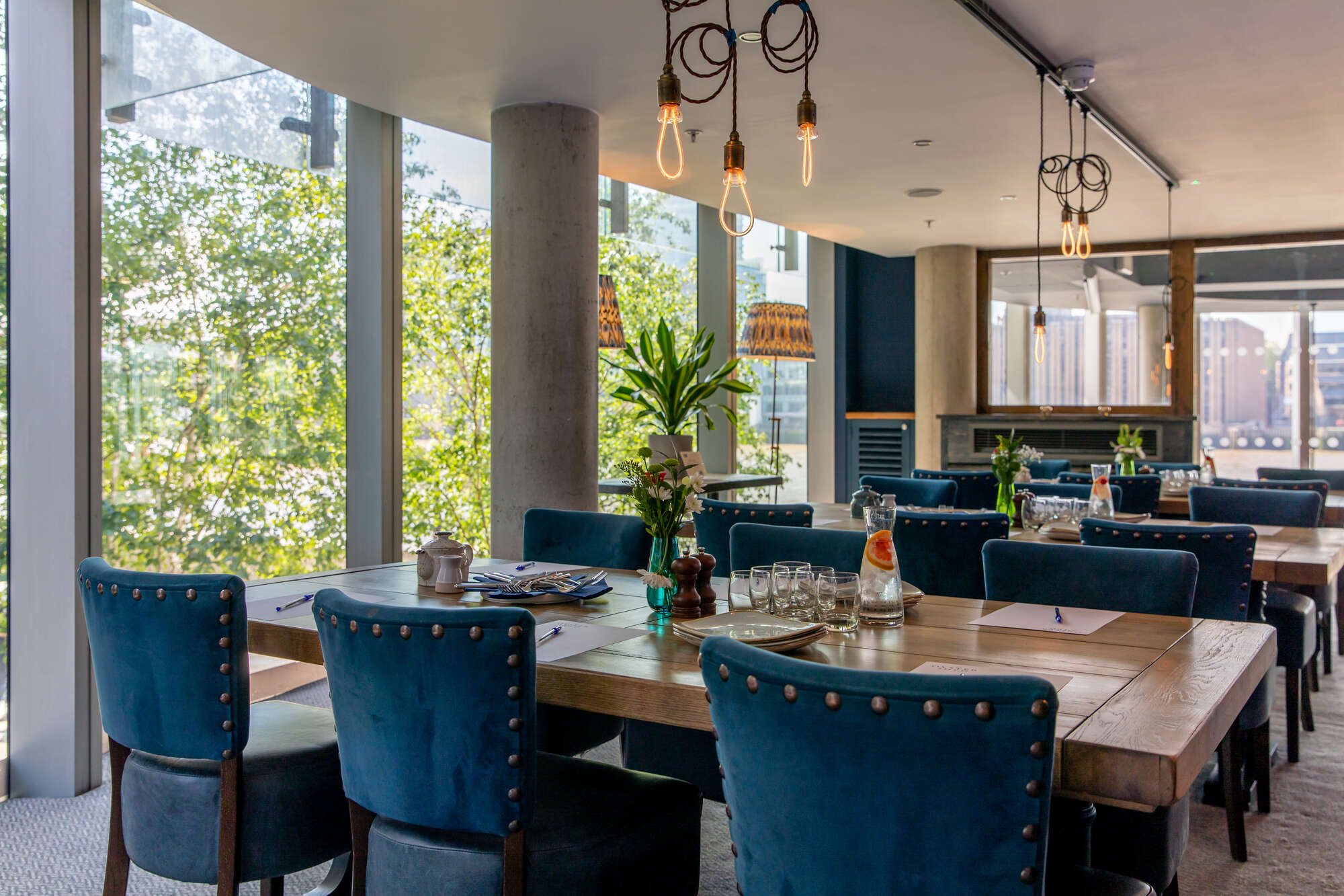 Stylish meeting space with wooden table and blue chairs for workshops and collaboration.