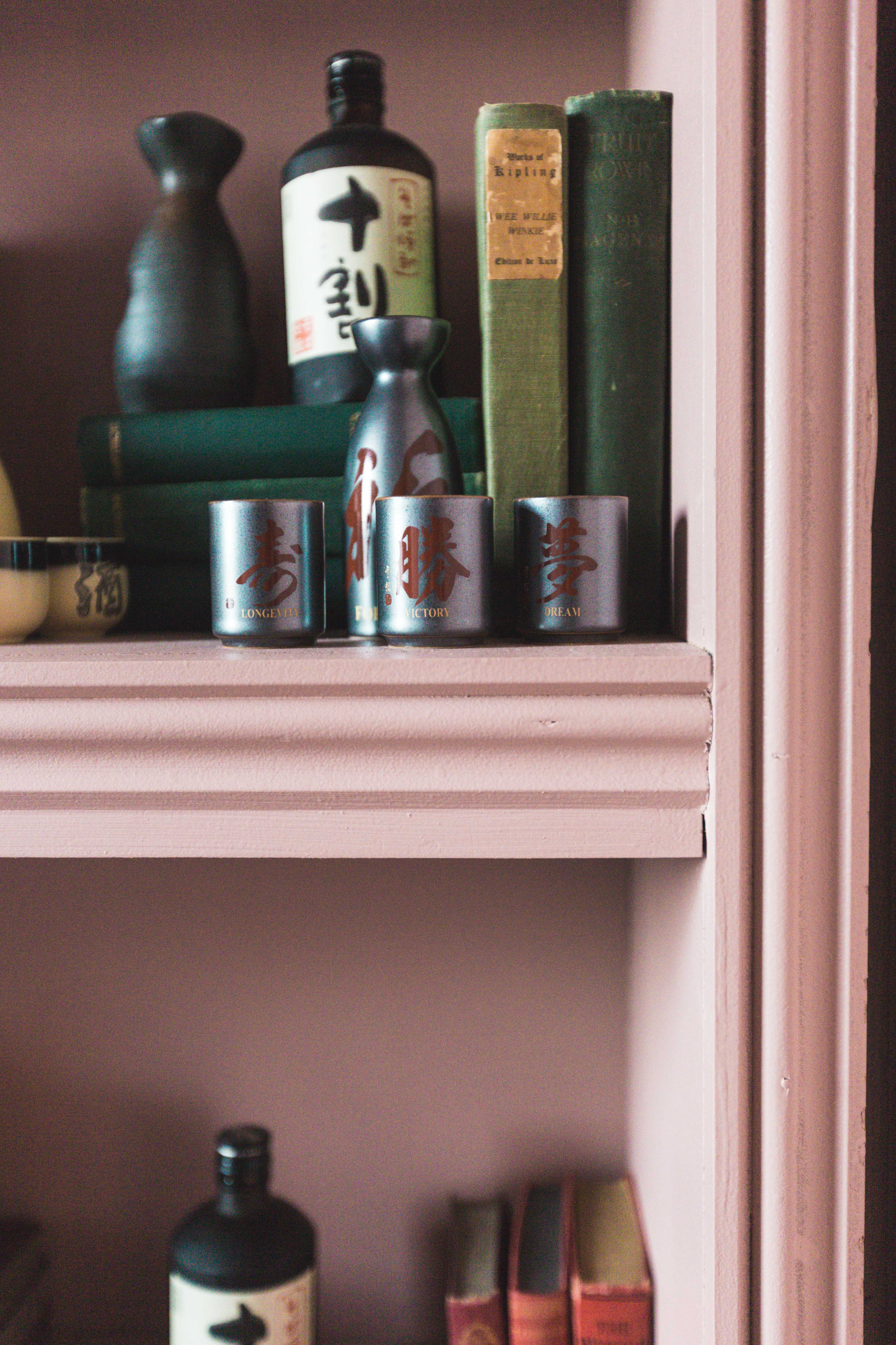 Whisky and Sake Bar shelf with decorative metallic cups for event decor inspiration.