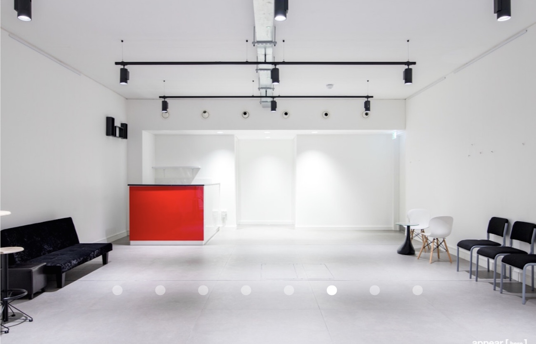 Versatile minimalist event space with sleek bar for corporate meetings and workshops.