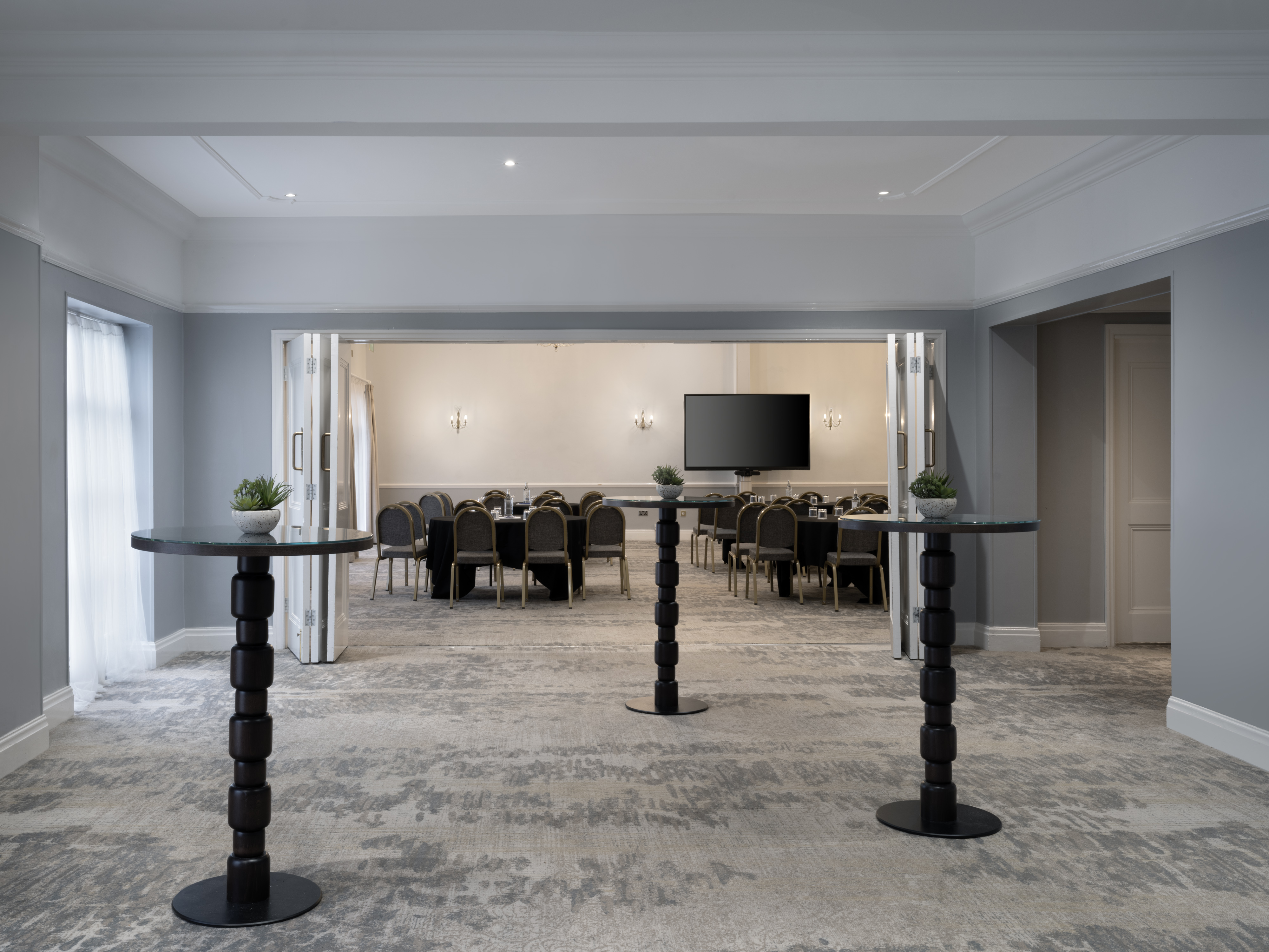Broughton Suite at Delta Hotels: modern event space with elegant round tables for meetings.