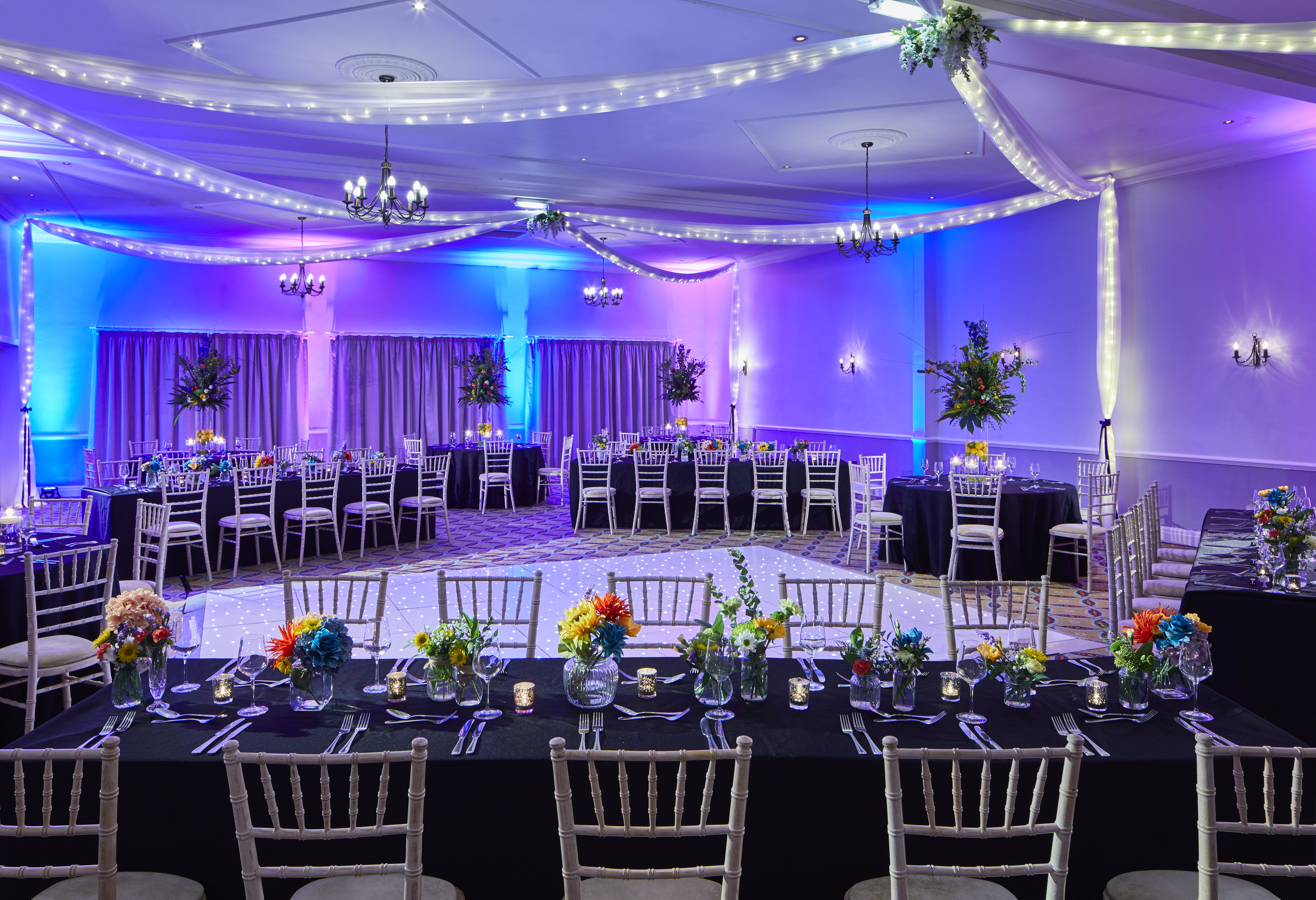 Elegant Broughton Suite event space with floral centerpieces for formal gatherings.