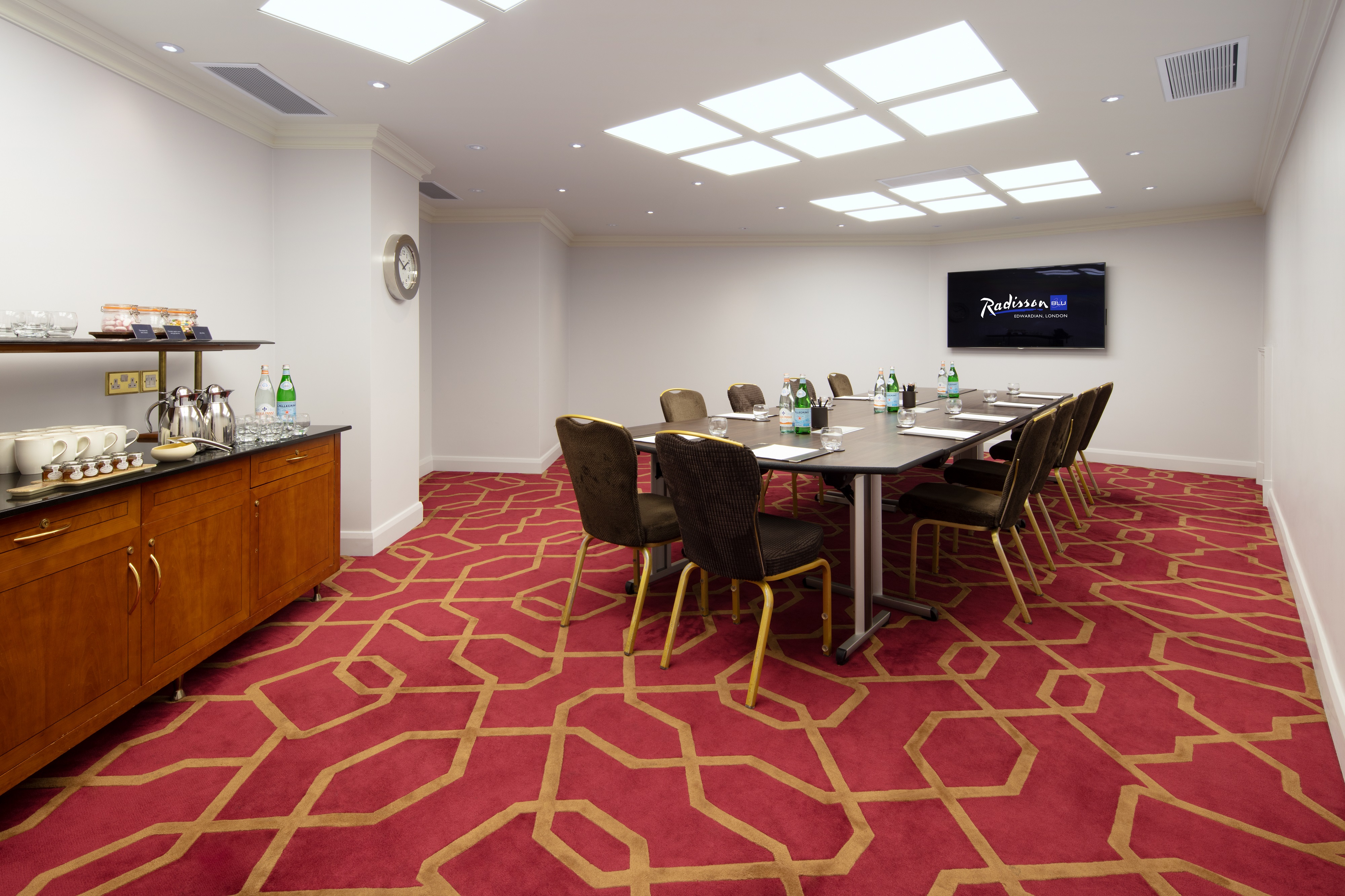 Private Room 42 at Radisson Blu Heathrow, modern meeting space with large table and screen.
