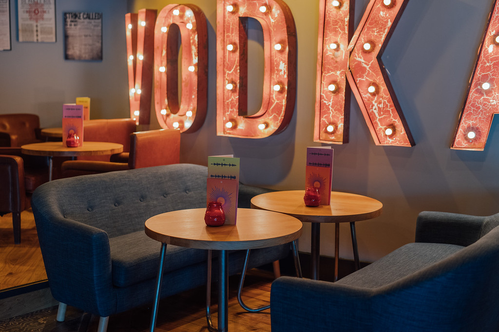 Stylish lounge in Revolution York with vintage "VODKA" sign, perfect for networking events.