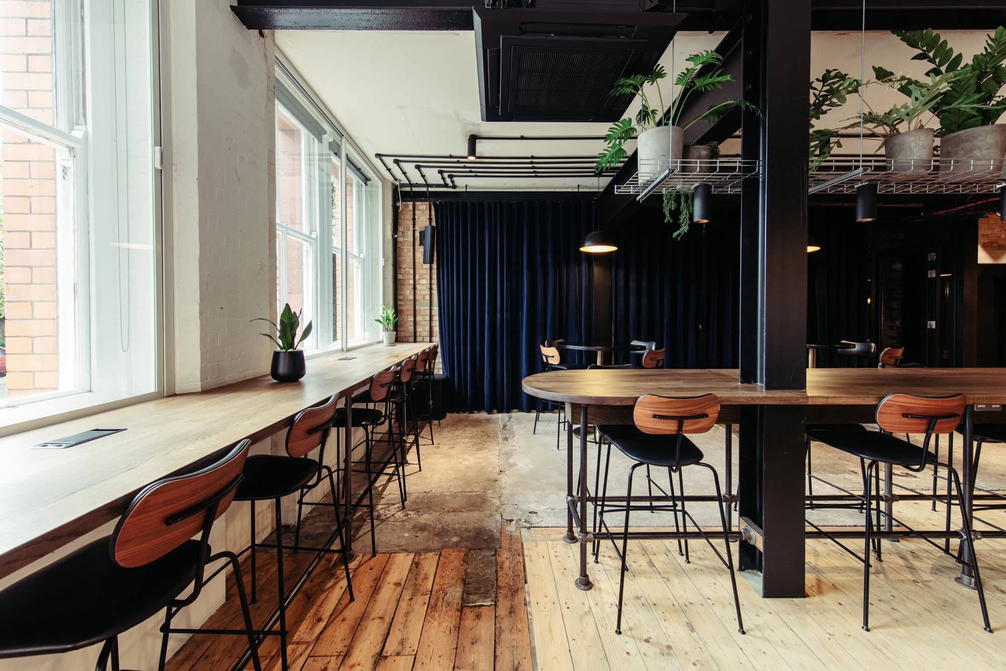 Industrial-chic lounge with high-top seating for co-working and networking events.