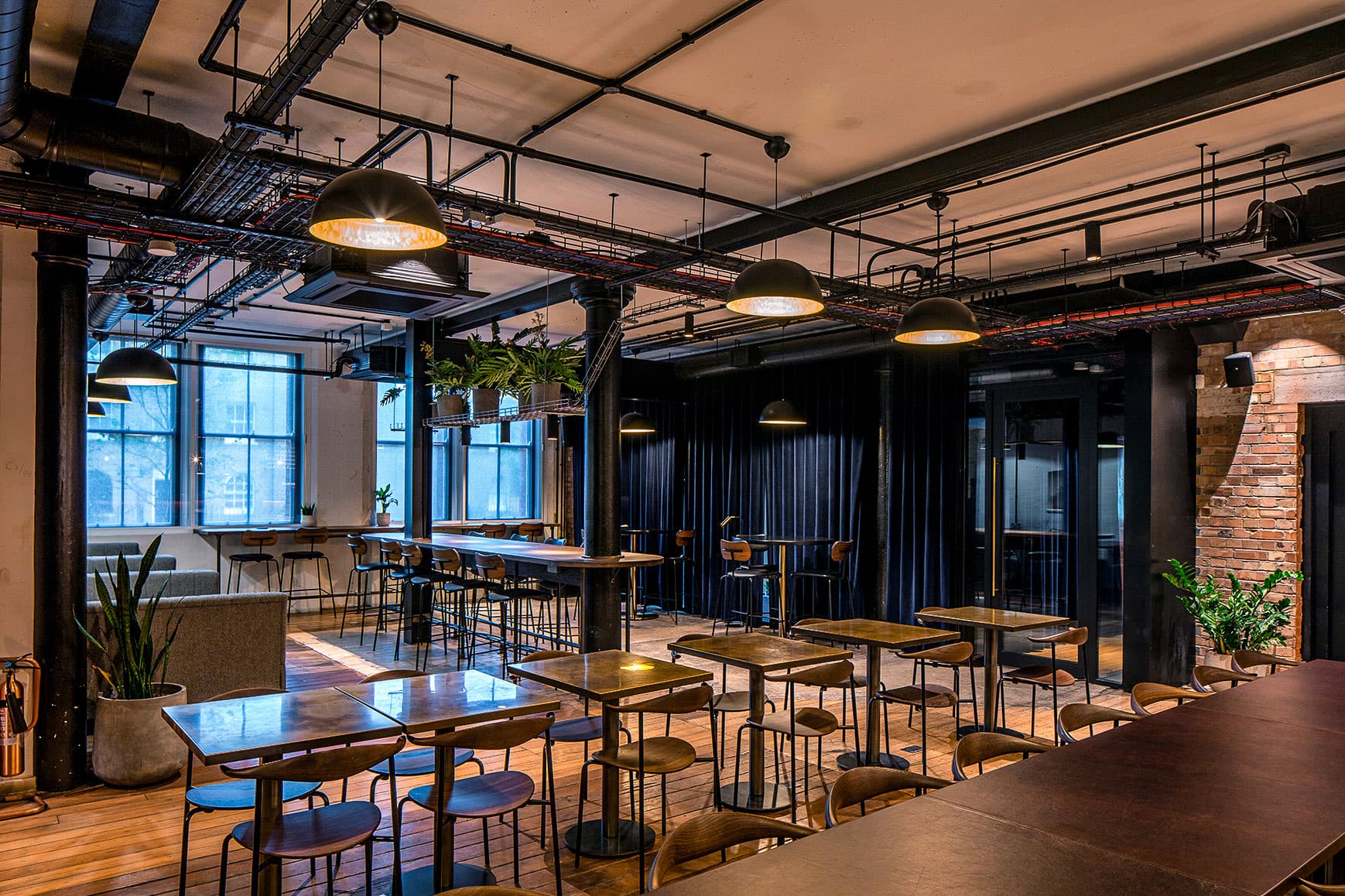 Industrial-chic lounge with flexible seating for networking and coworking events.