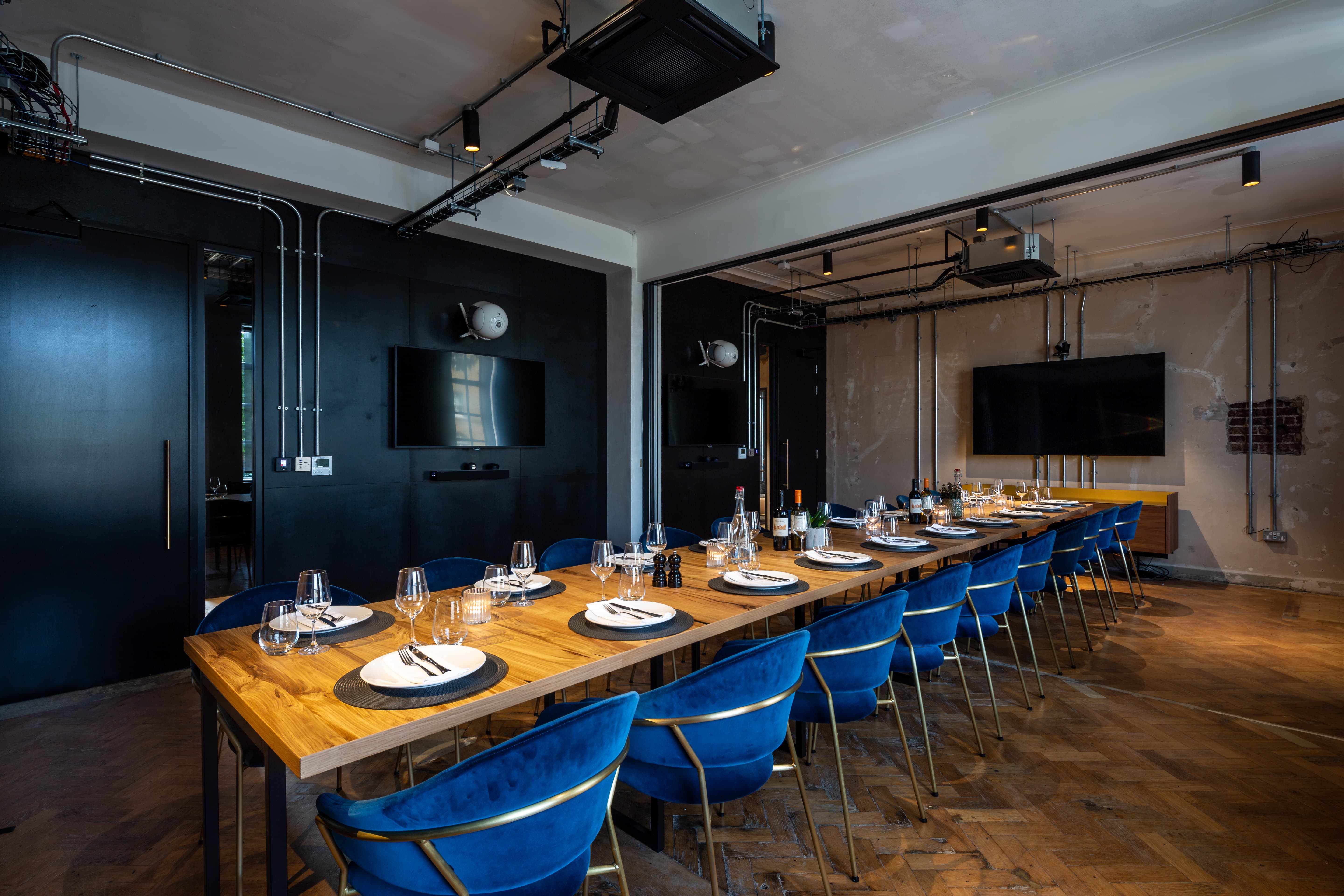 Industrial-chic meeting room with long table for corporate dinners and off-site meetings.