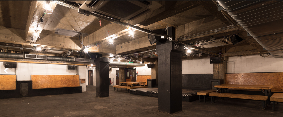 Versatile industrial event space with exposed beams for workshops and parties.