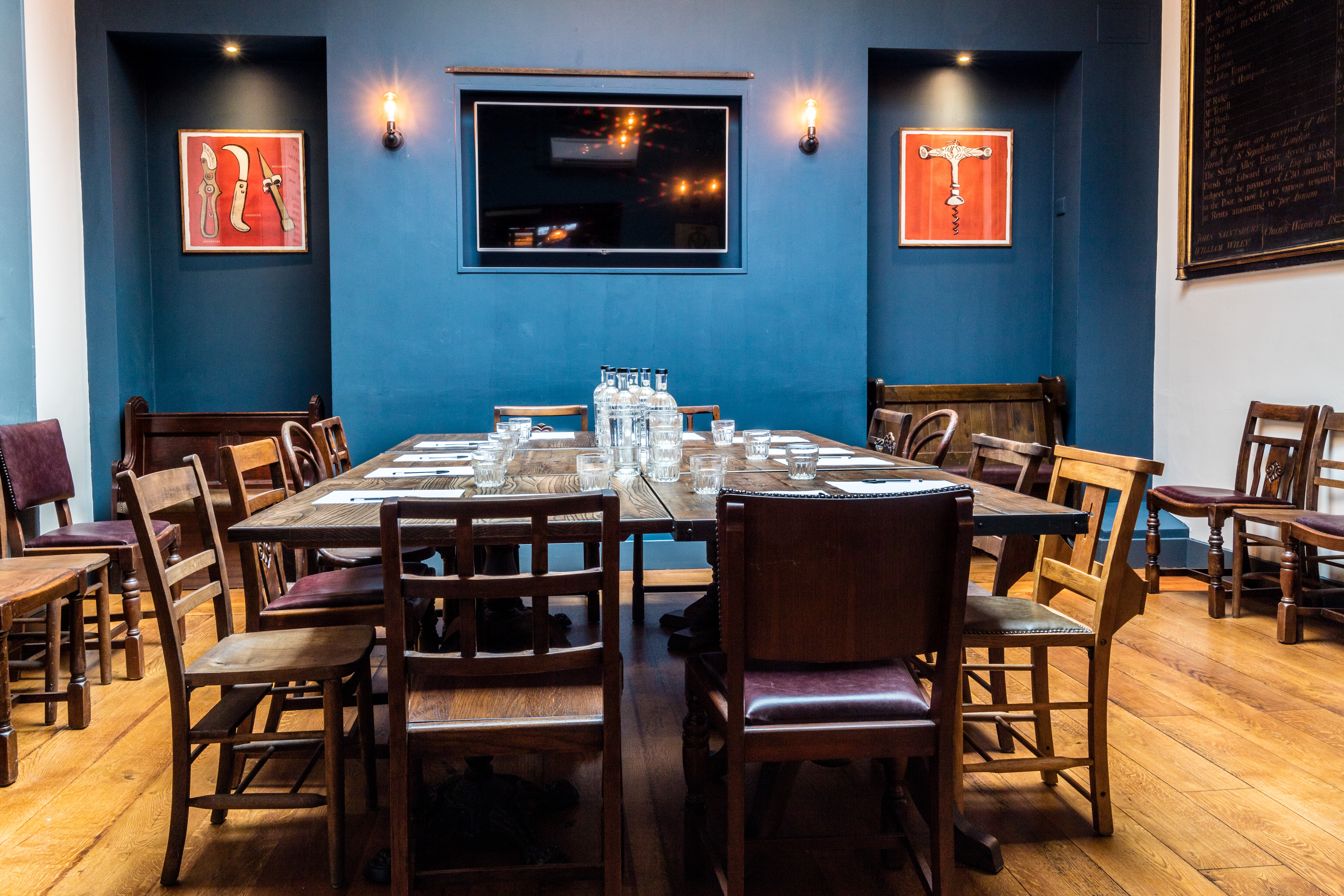 Intimate meeting space with wooden tables, ideal for gatherings and presentations.