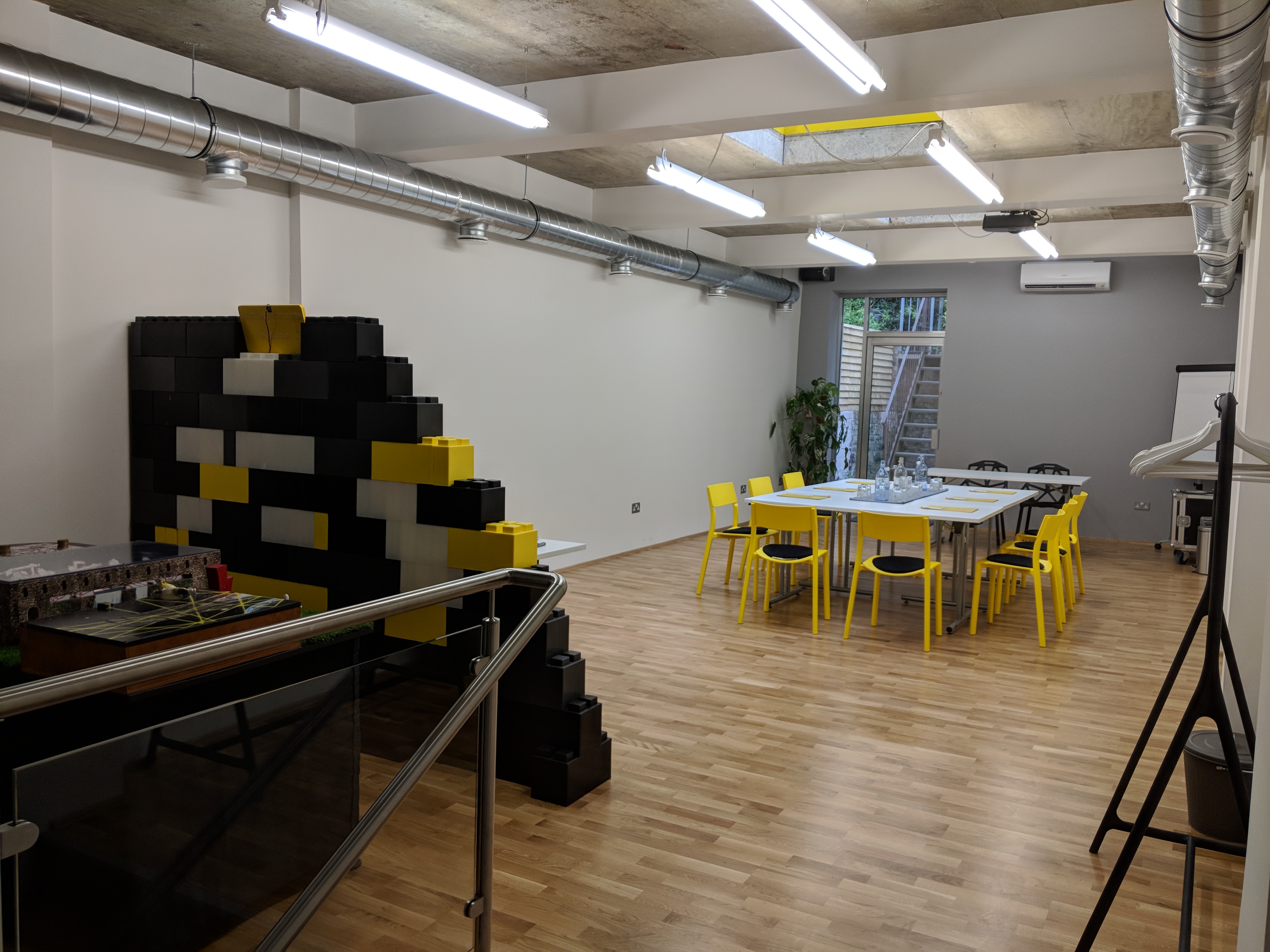 Versatile clueQuest conference room with bright yellow chairs for workshops and brainstorming.