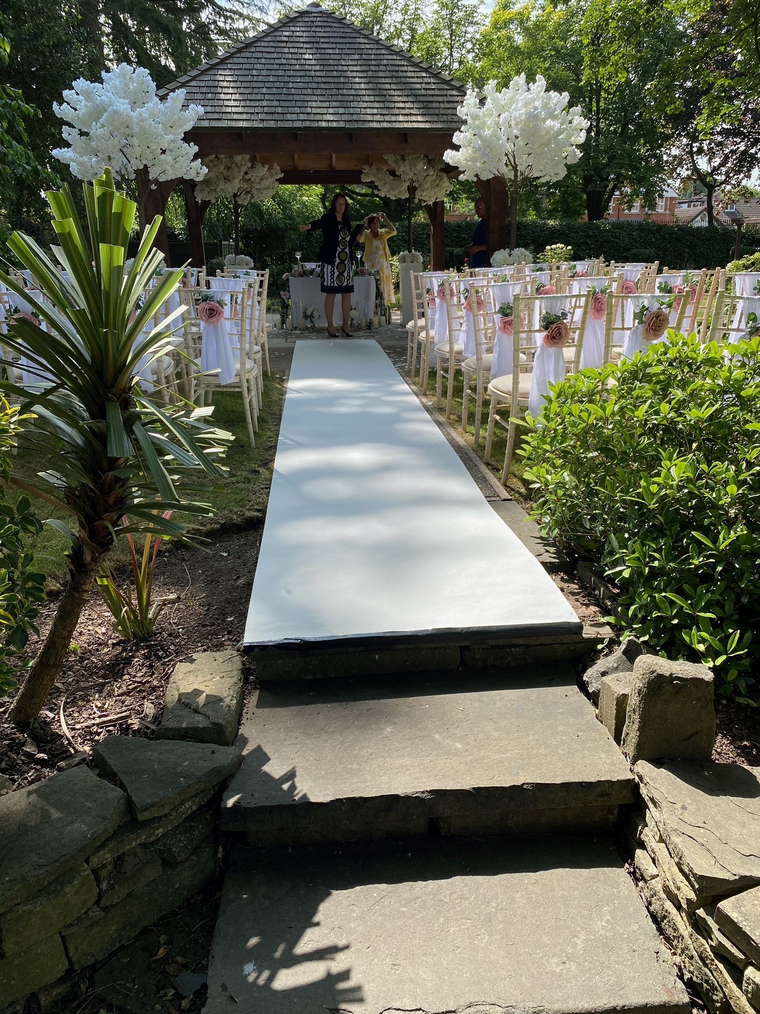 Cheshire Suite outdoor wedding venue with floral chairs and lush greenery.