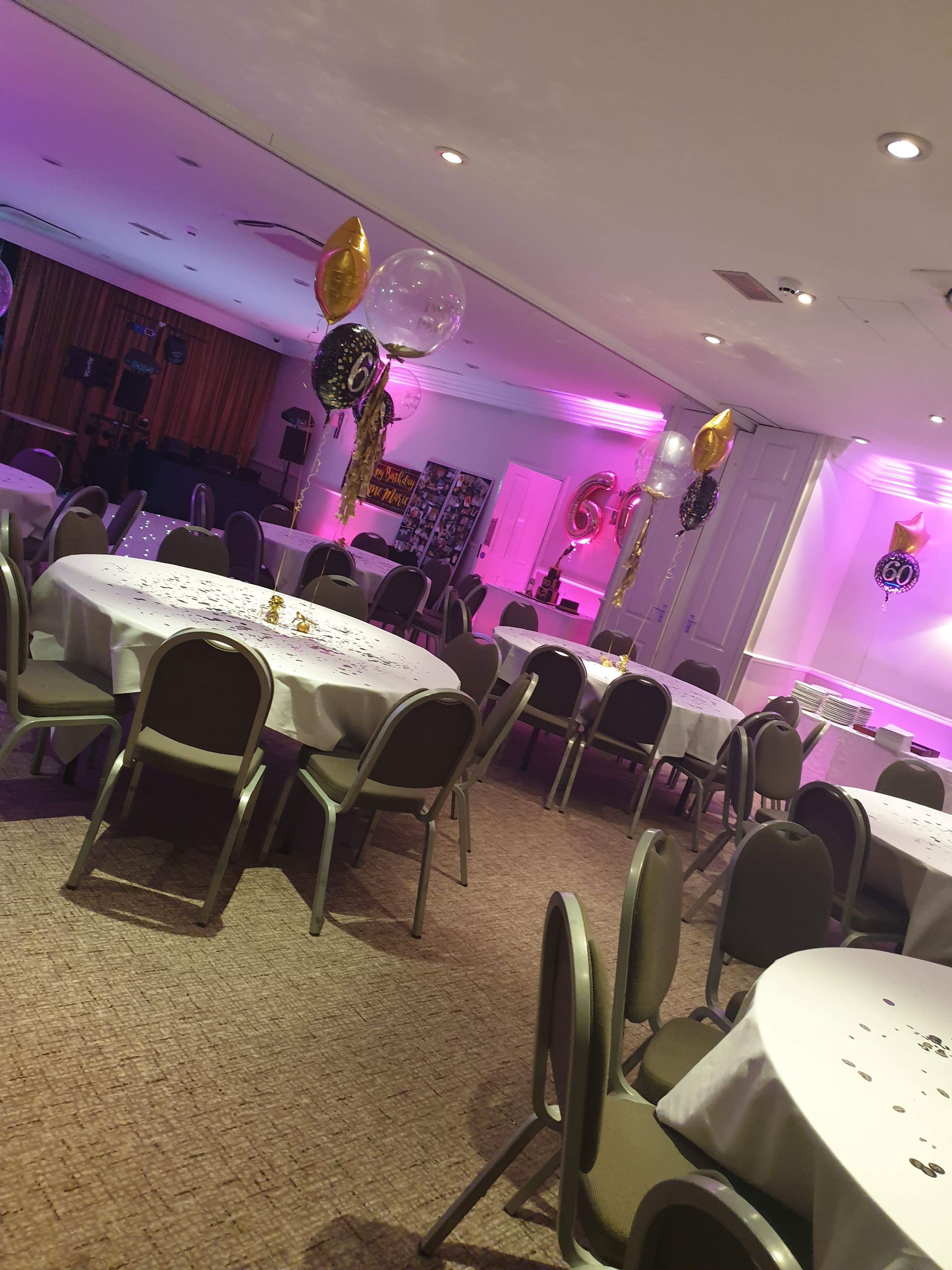 Cheshire Suite event space with round tables and pink lighting for milestone celebrations.