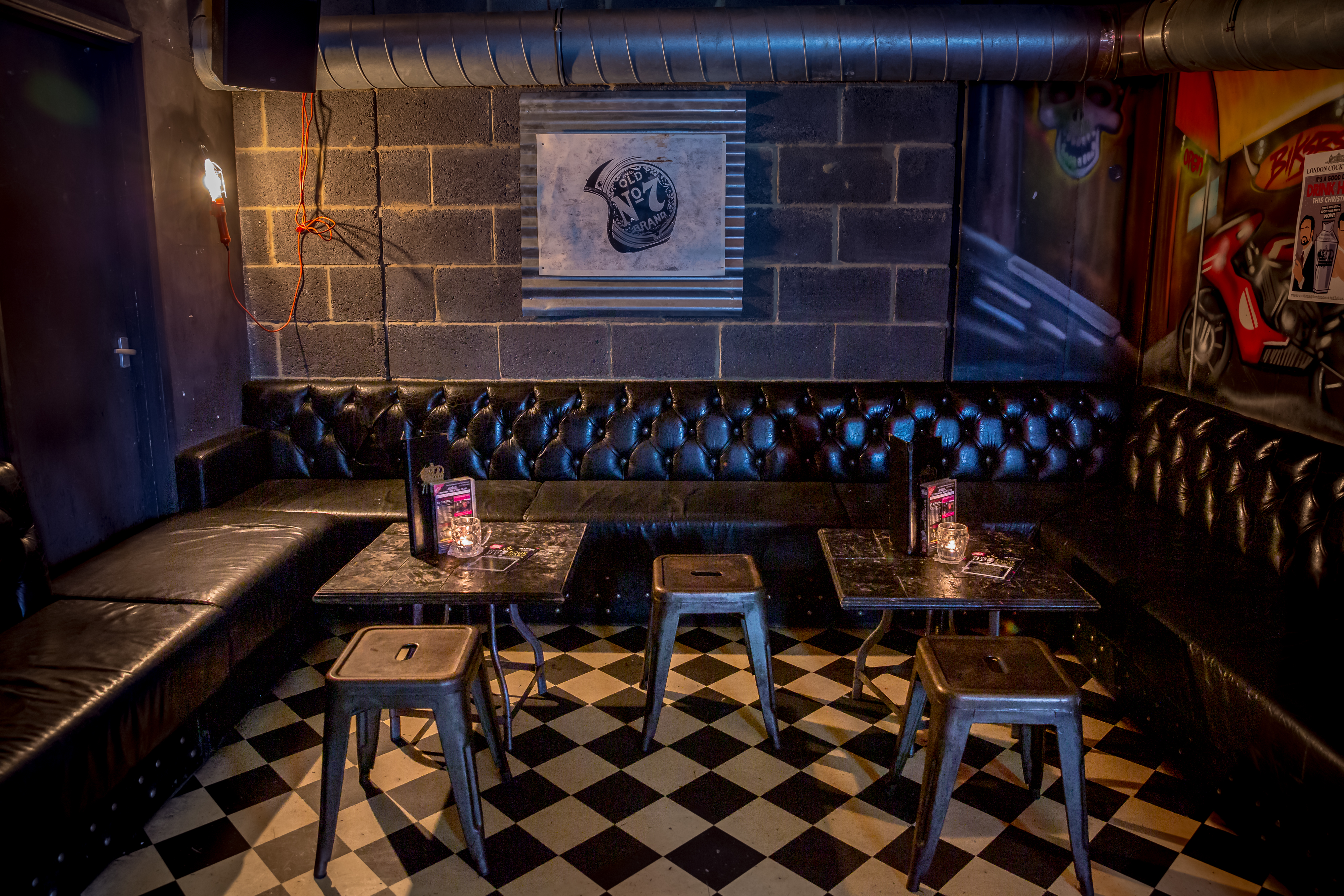 Backstage lounge at The Cocktail Club Shoreditch, featuring black leather seating for events.