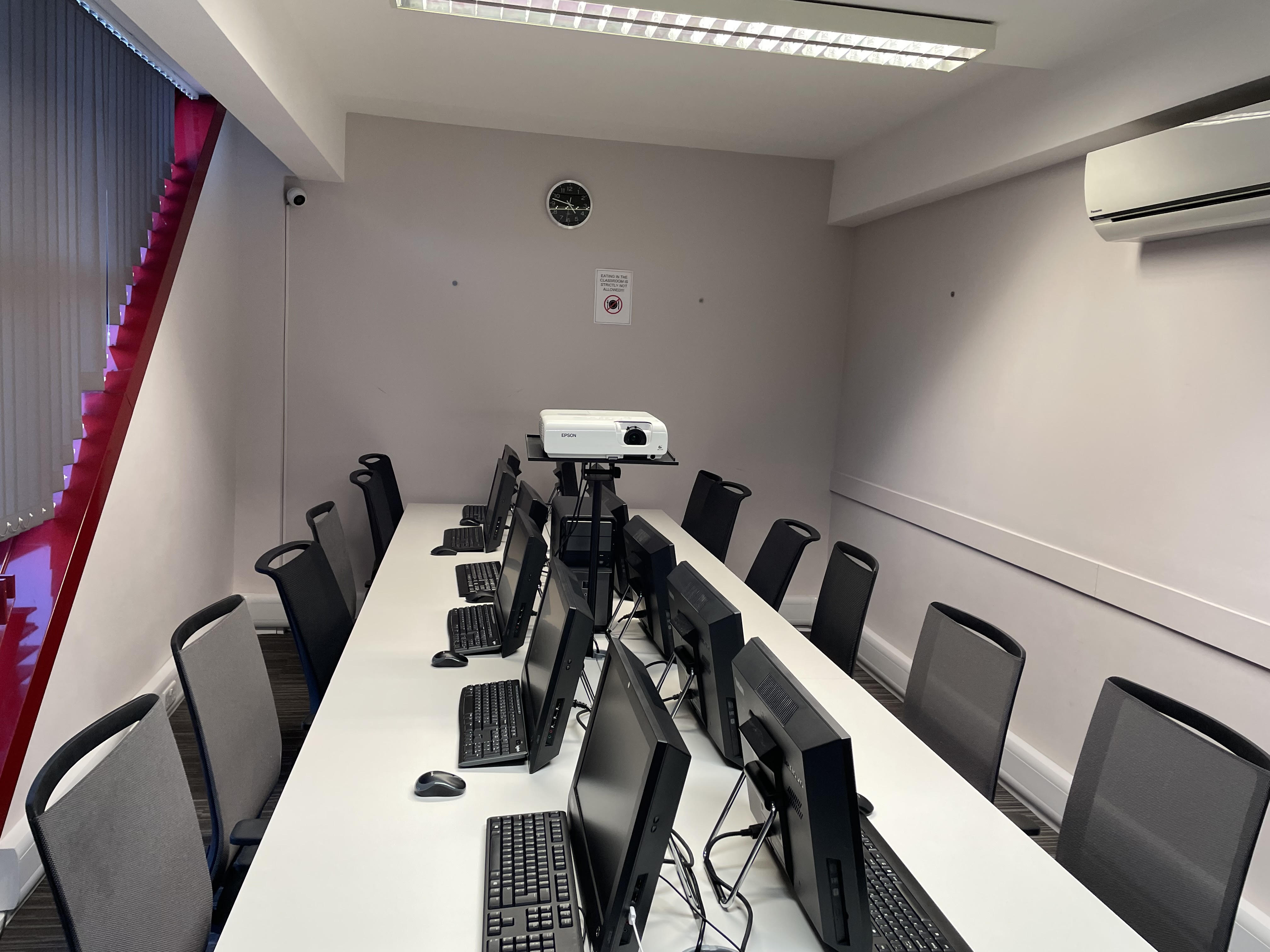 Modern meeting room with workstations and projector for training sessions.
