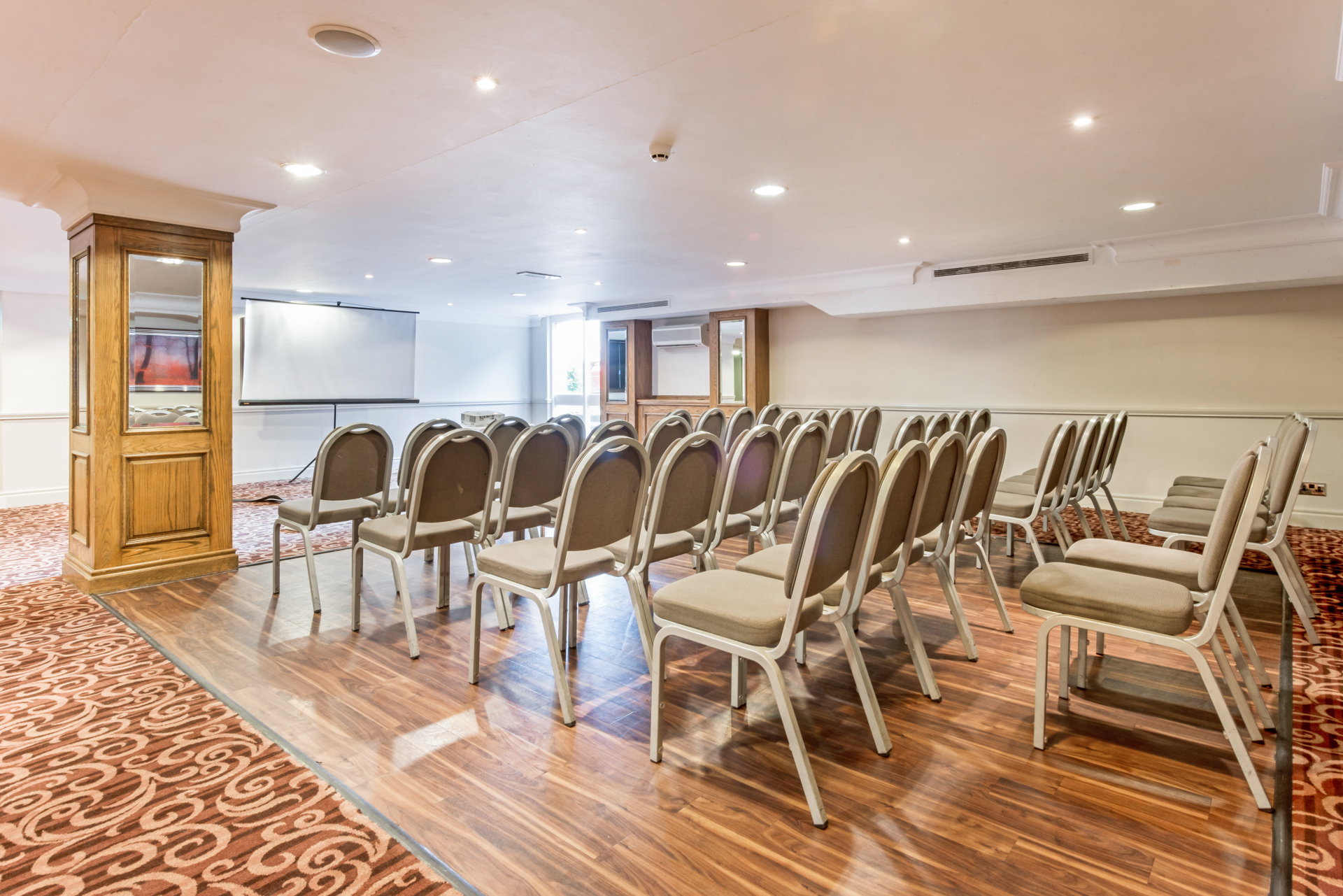 Tatton Suite meeting room with chairs and projection screen, ideal for conferences and workshops.