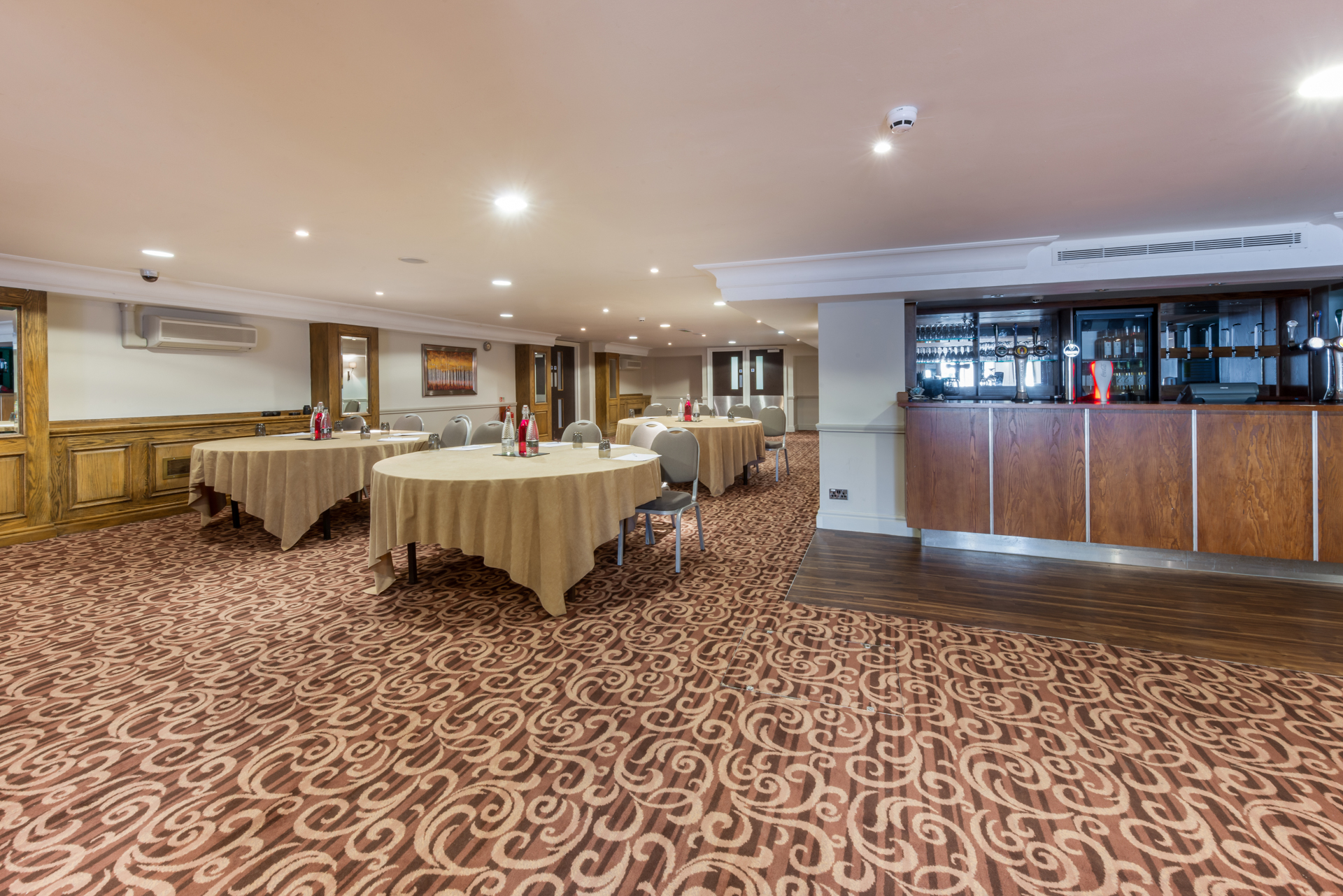 Tatton Suite event space with round tables, ideal for meetings and gatherings.