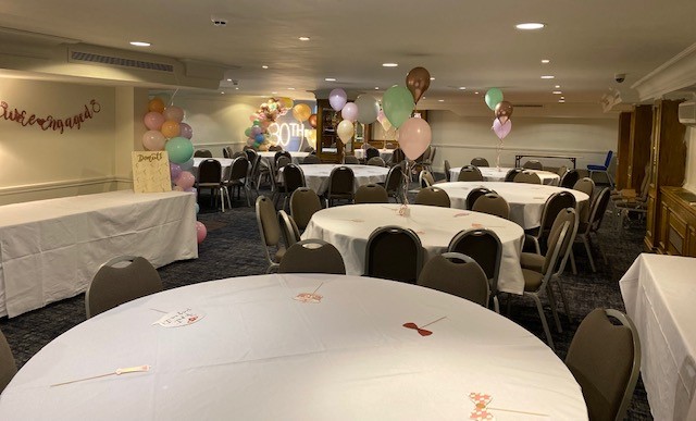 Tatton Suite event space with round tables, balloons for celebrations and networking.