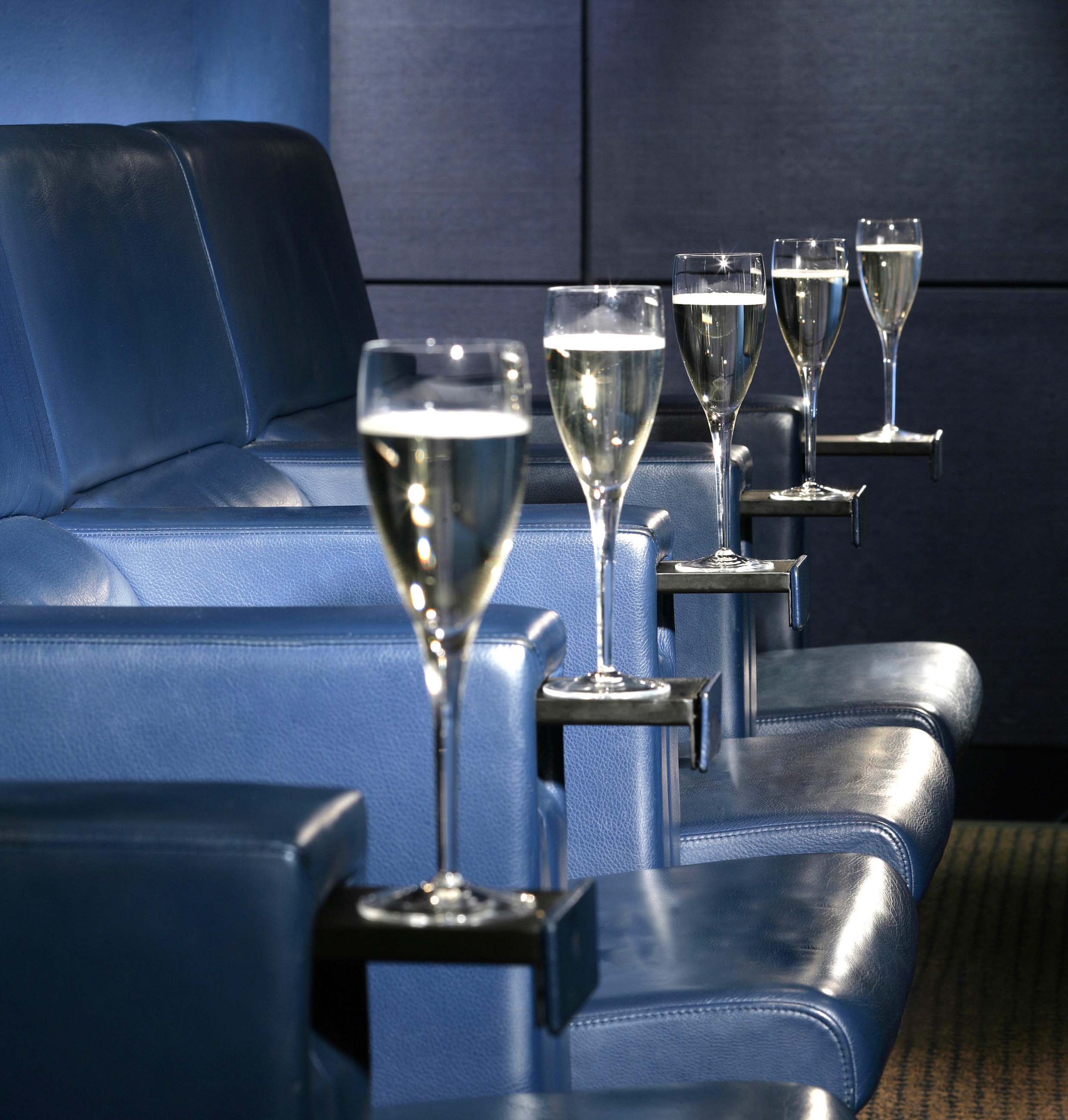 Elegant champagne flutes in plush blue chairs at The Screening Room, One Aldwych event.