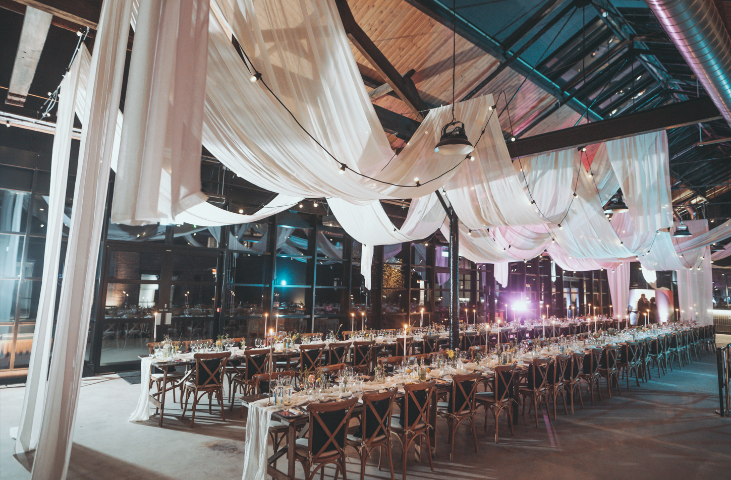 Elegant wedding venue with long table setup and soft lighting for memorable events.