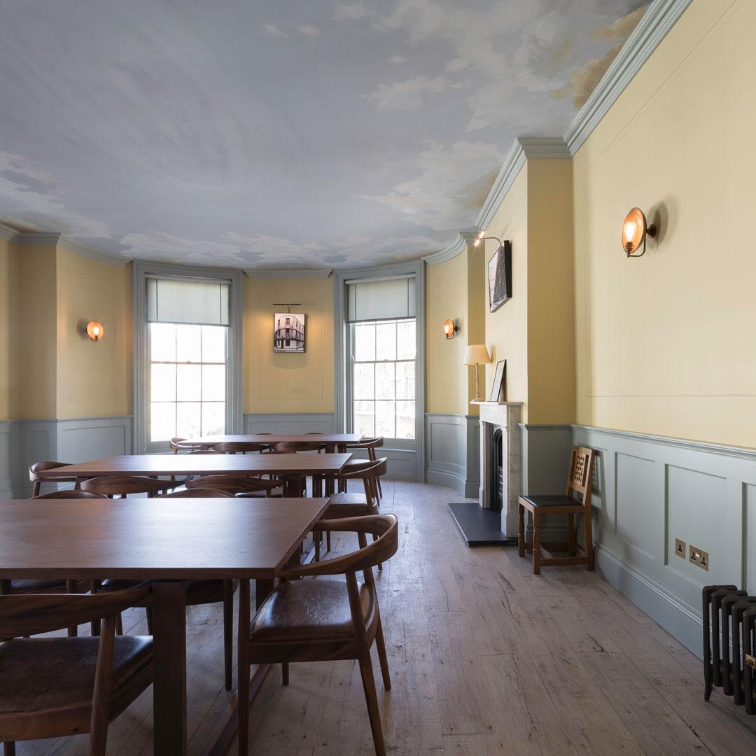 Elegant meeting room with wooden tables, ideal for workshops and intimate gatherings.