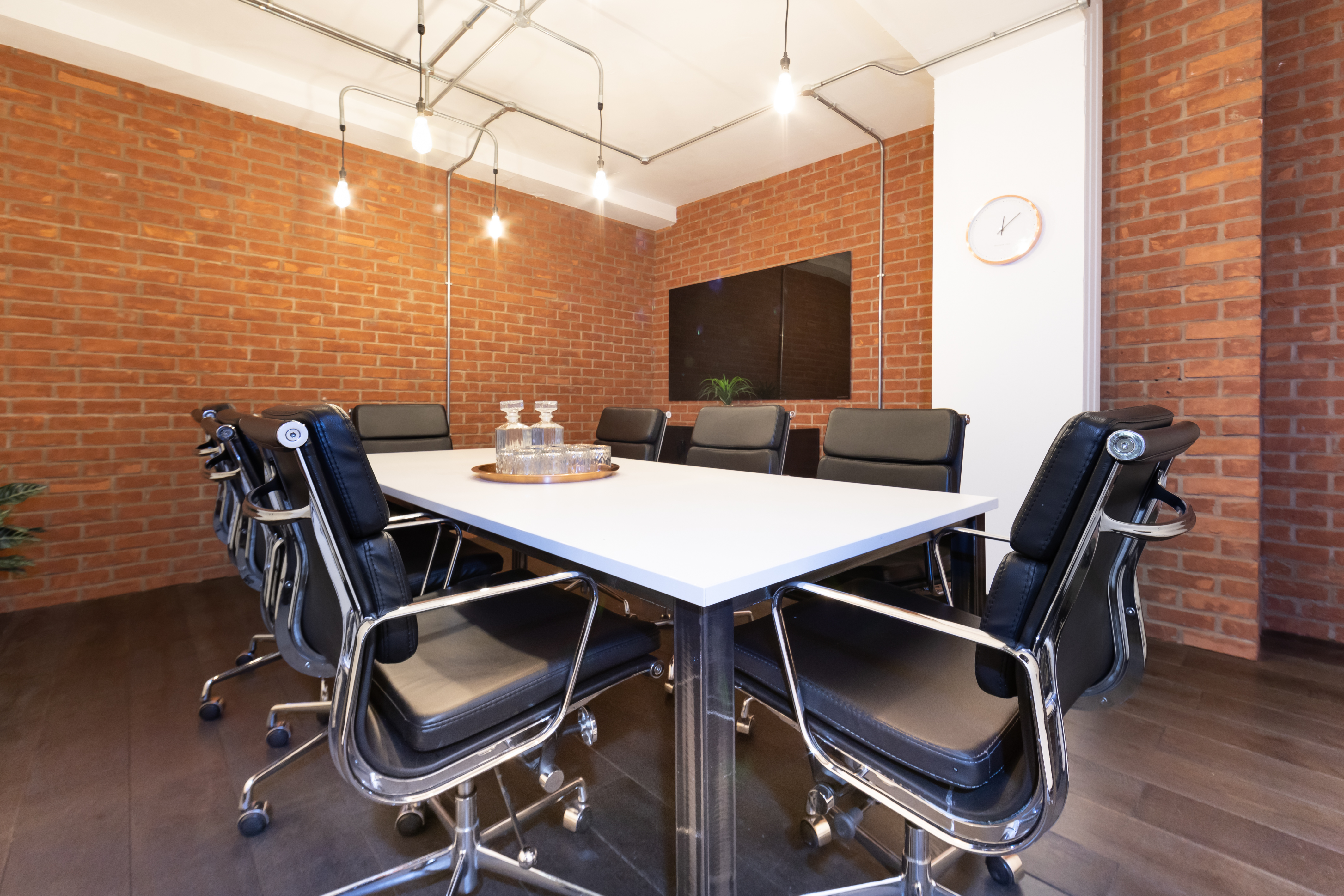 Modern conference room with industrial brick walls, ideal for meetings and brainstorming sessions.