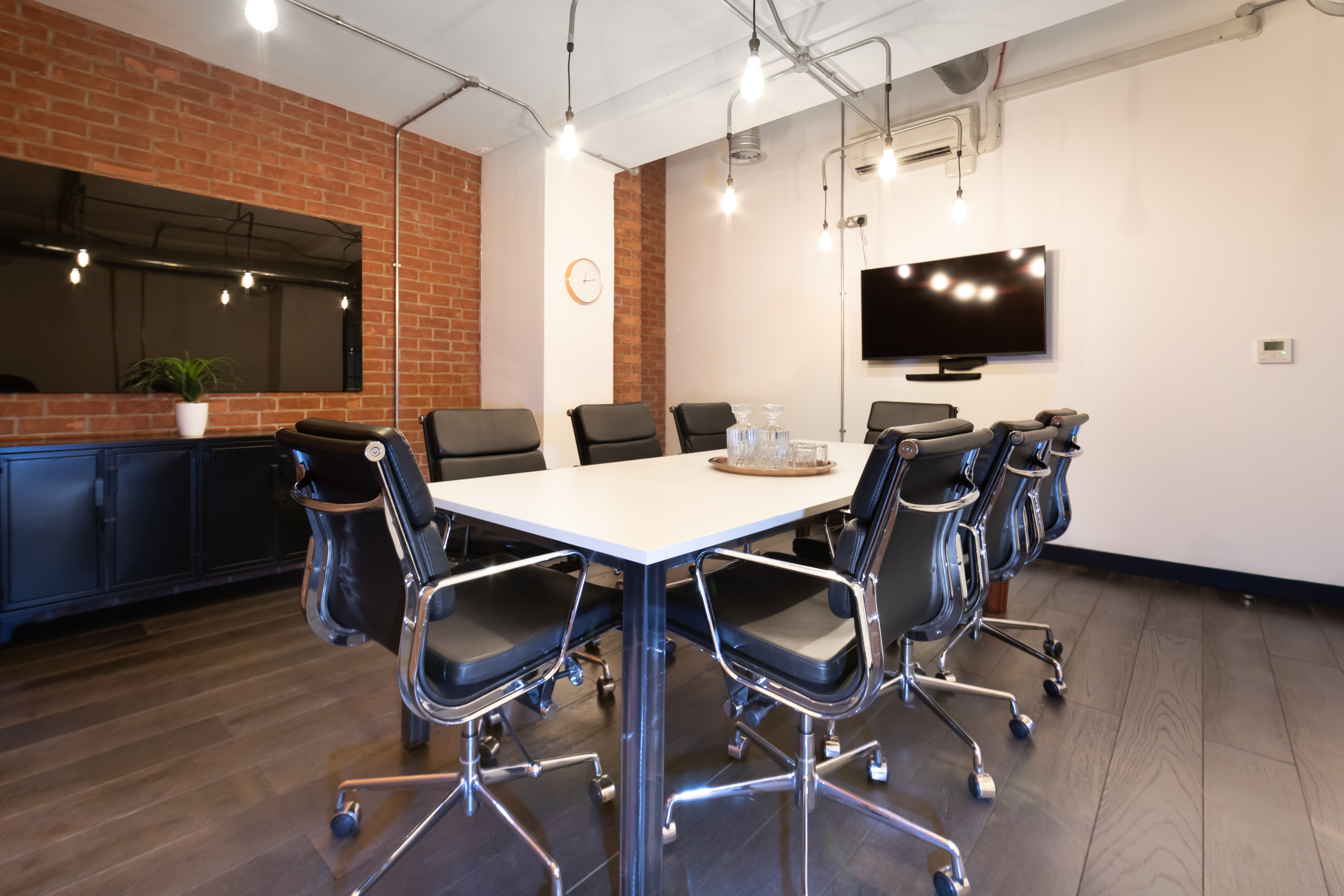 Modern conference room with sleek table, smart tech; ideal for meetings and collaborations.