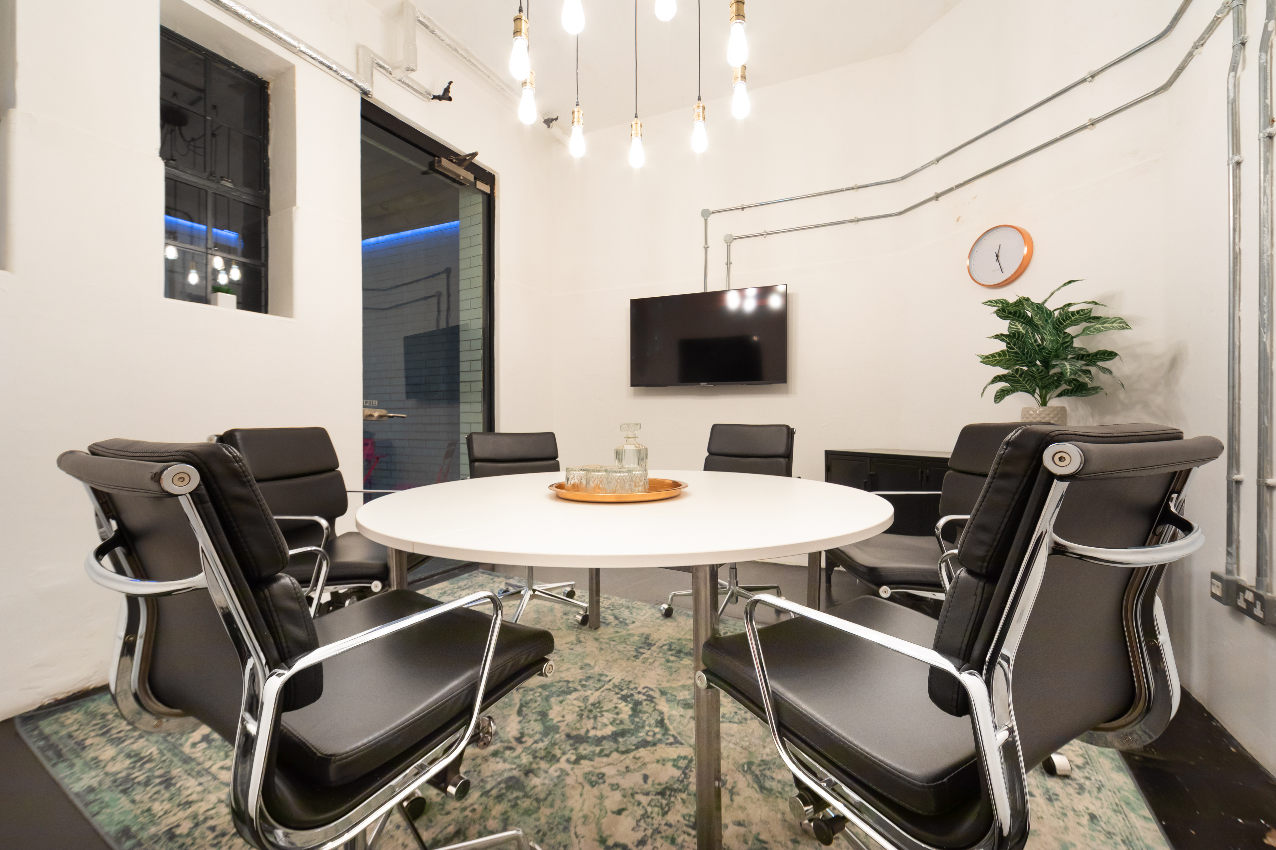 Modern meeting room with round table, ergonomic chairs for collaboration and productivity.