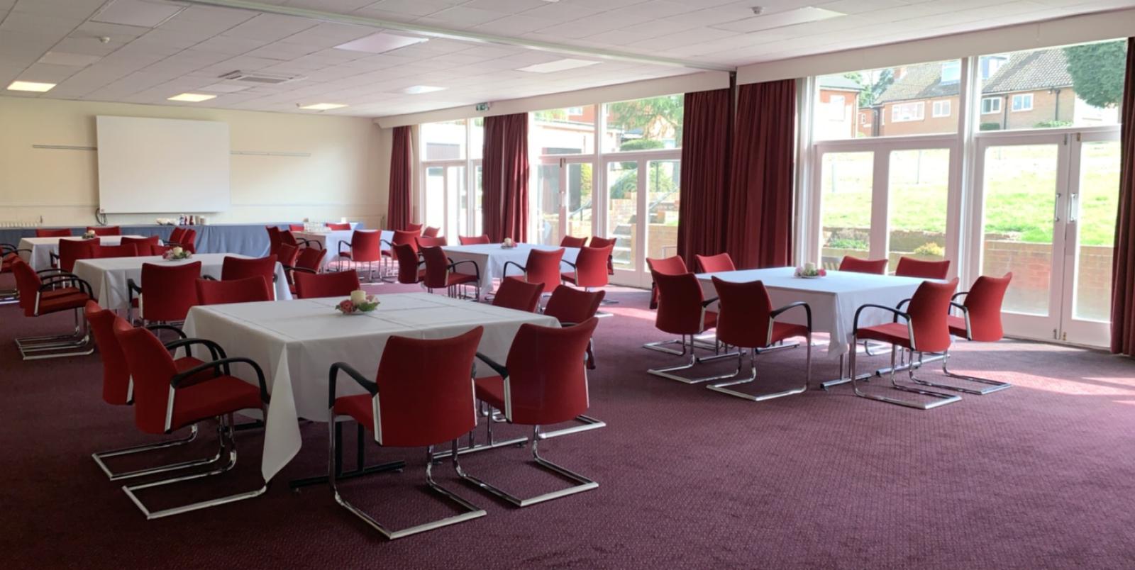 Oak & Cedar Suite with red chairs, perfect for meetings and workshops at The Beeches.